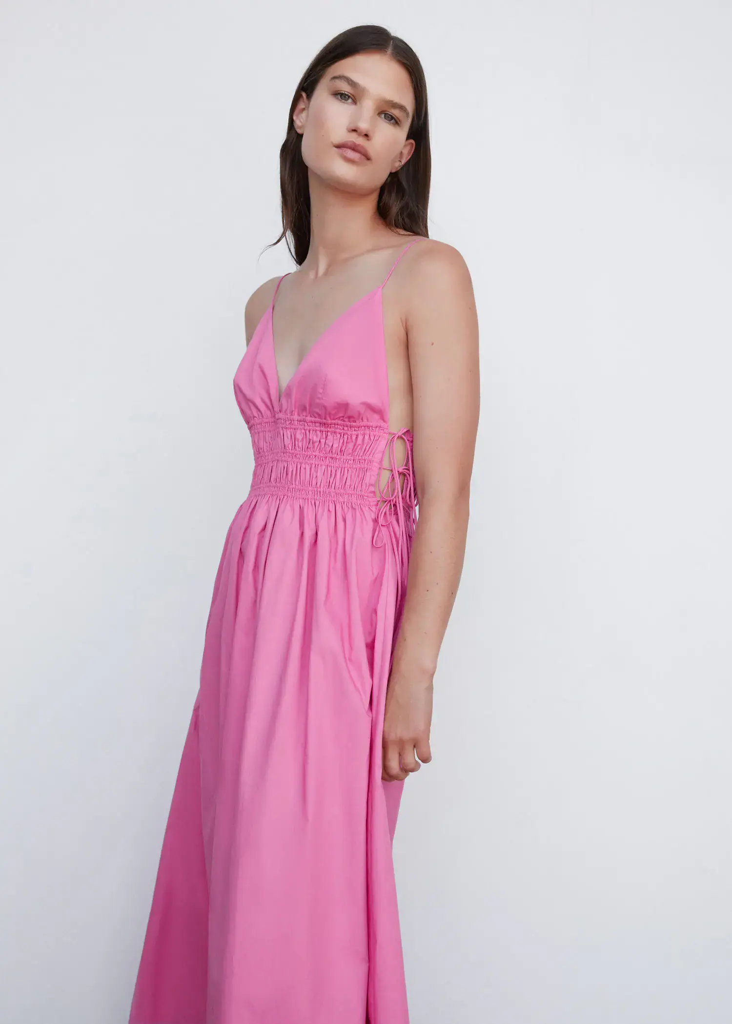 Mango Cotton dress with side ties. a woman wearing a pink dress standing next to a wall. 