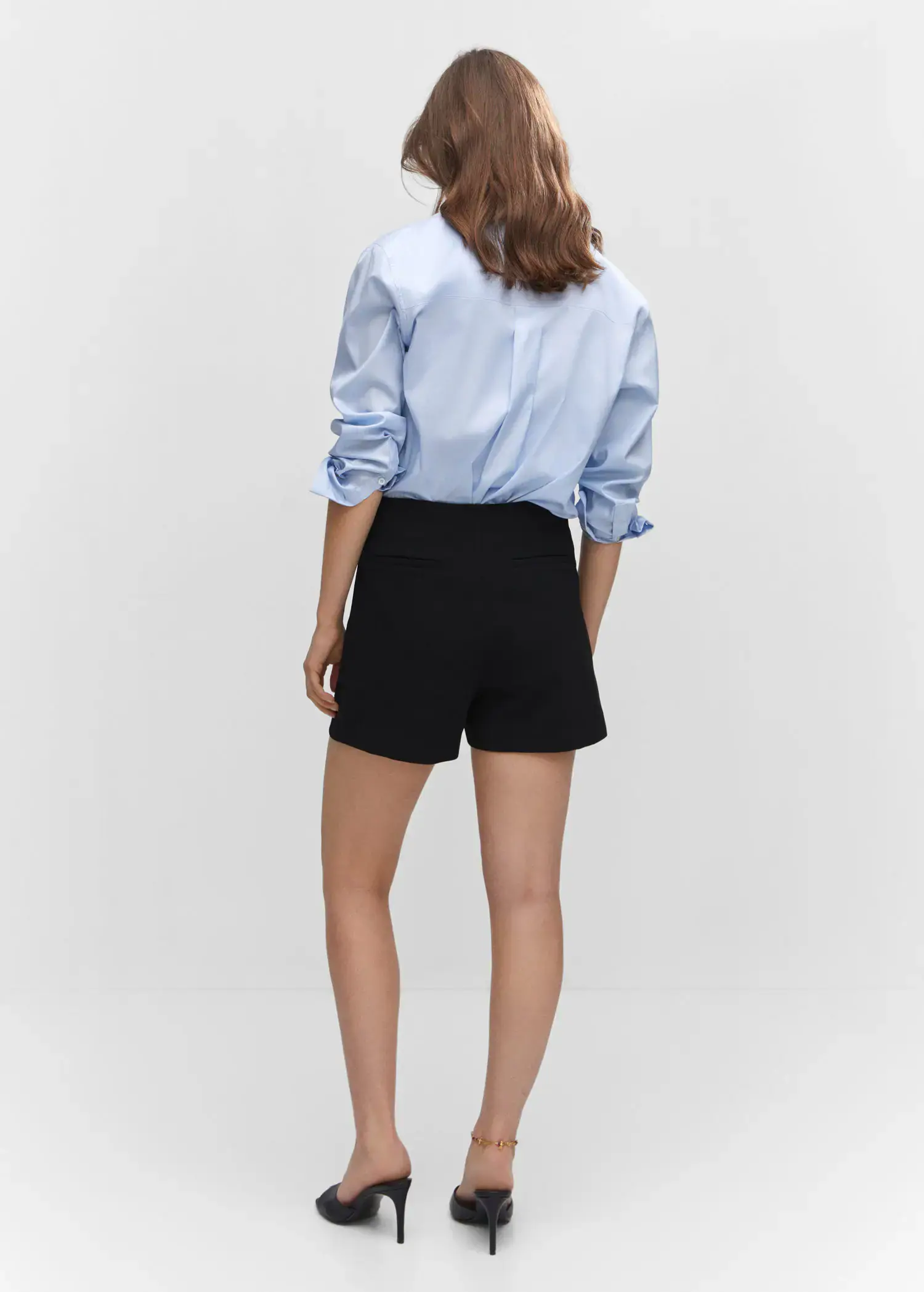 Mango High-waist straight shorts. a woman wearing black shorts and a light blue shirt. 