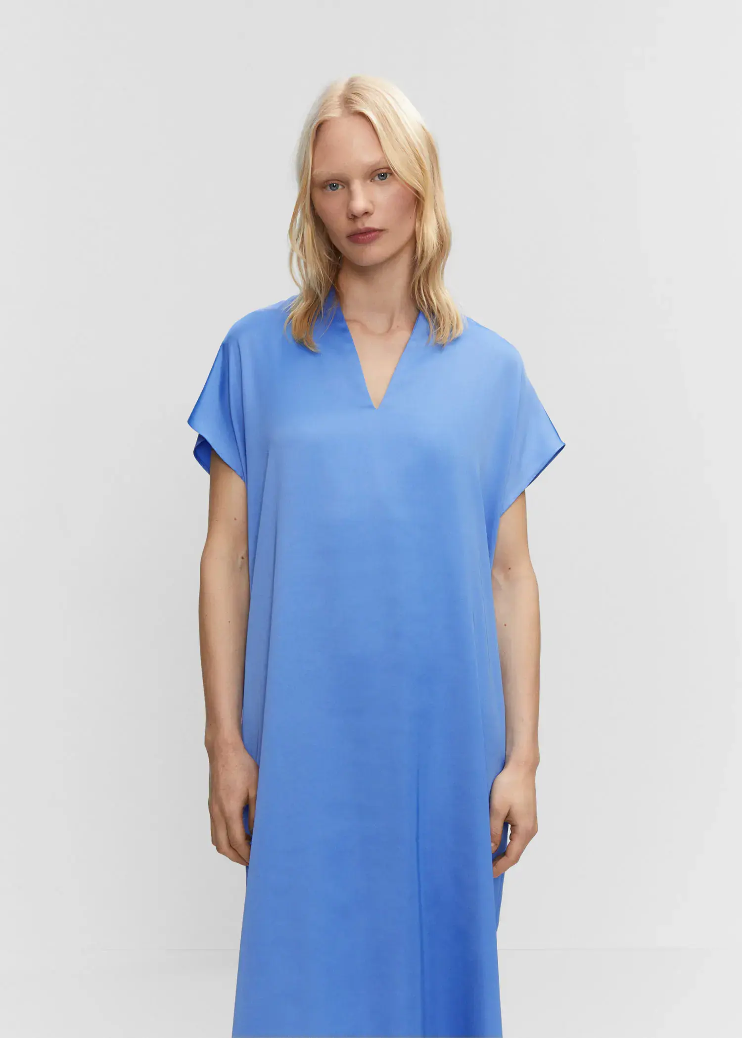Mango Side slit dress. a woman wearing a blue dress standing in front of a white wall. 