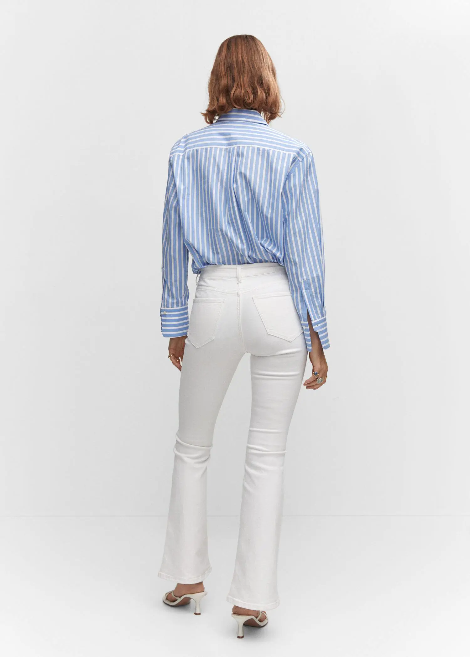 Mango Medium-rise flared jeans . a person wearing white pants and a blue shirt. 