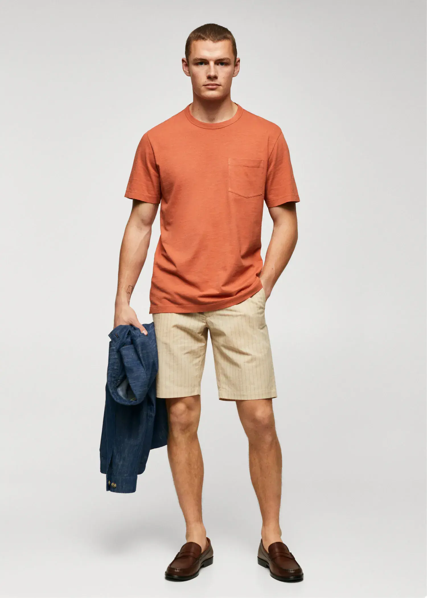 Mango 100% cotton t-shirt with pocket. a young man in shorts and an orange t-shirt. 