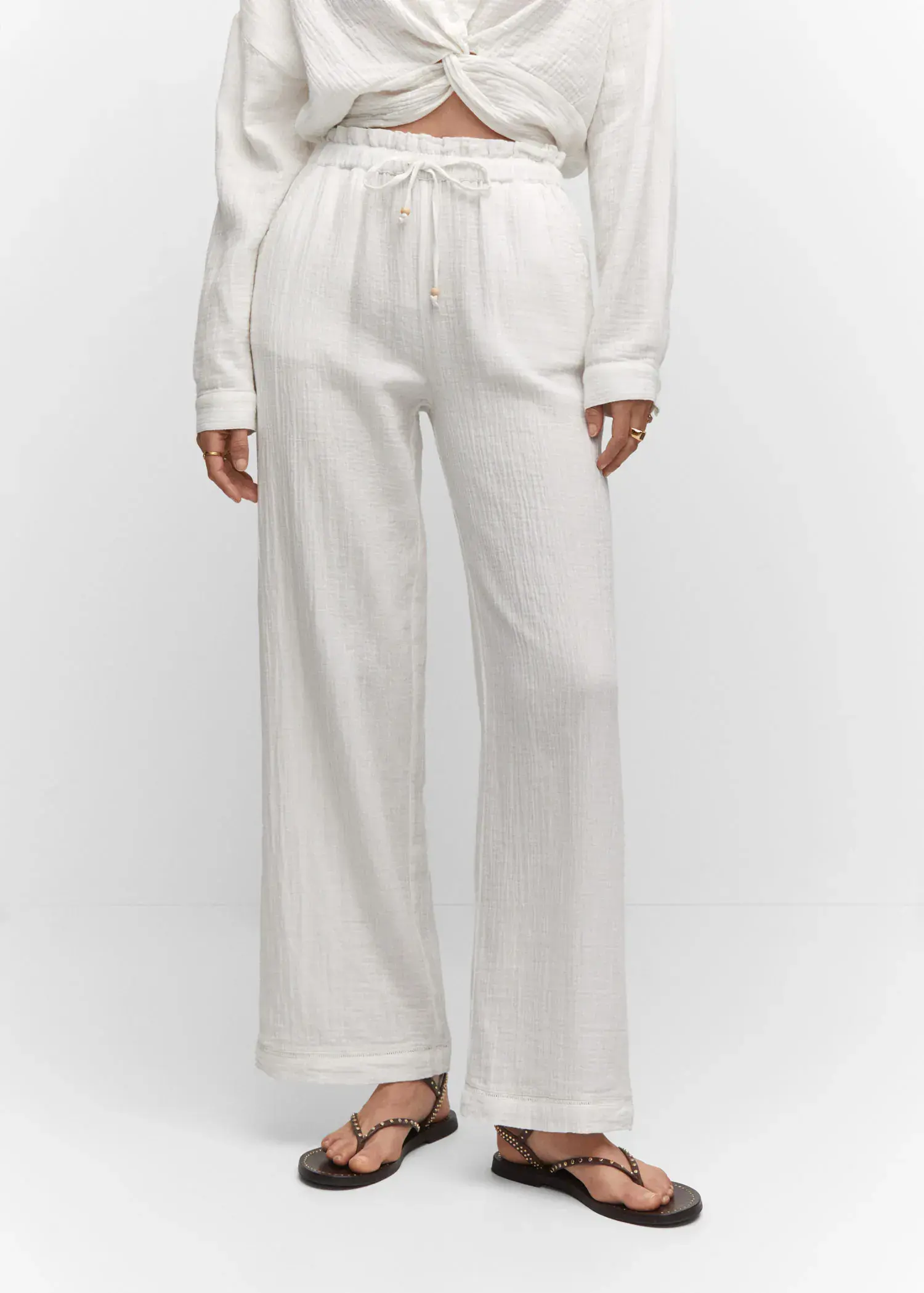 Mango Bow textured trousers. a person wearing white pants and a white shirt. 