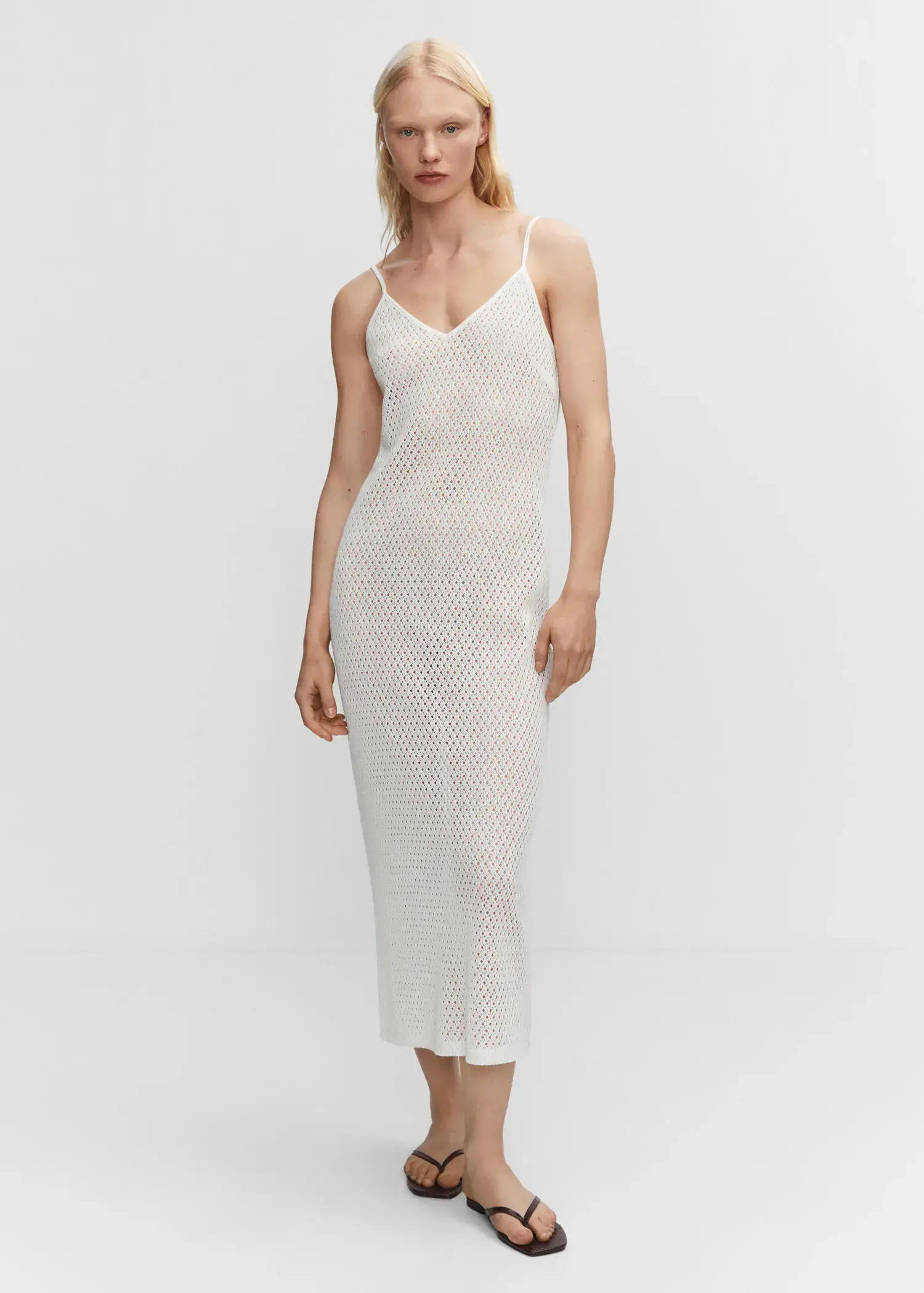 Mango Long openwork knitted dress. a woman in a white dress standing in front of a white wall. 
