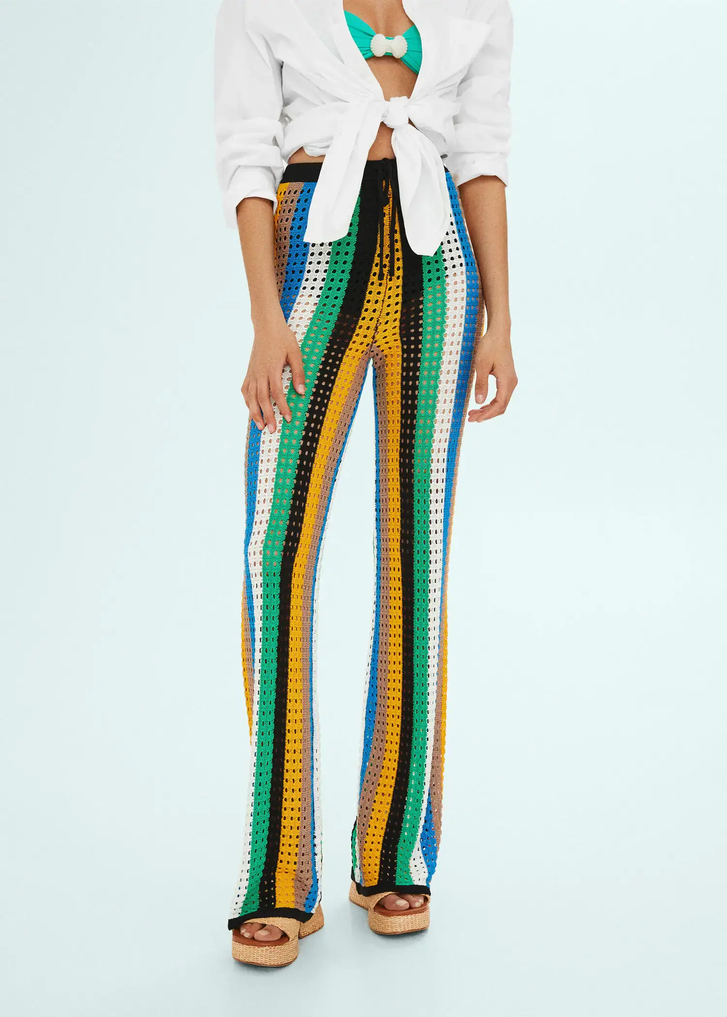 Mango Openwork knit trousers. a woman wearing a white shirt and colorful pants. 