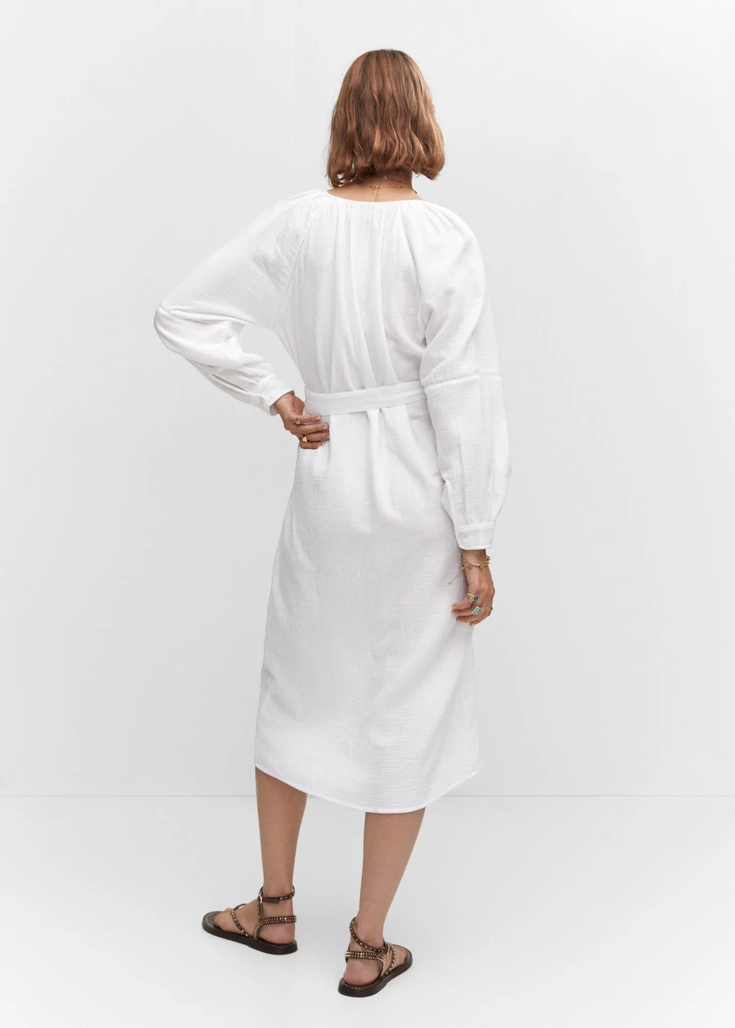 Mango Belt cotton dress. a woman wearing a white dress standing in front of a wall. 