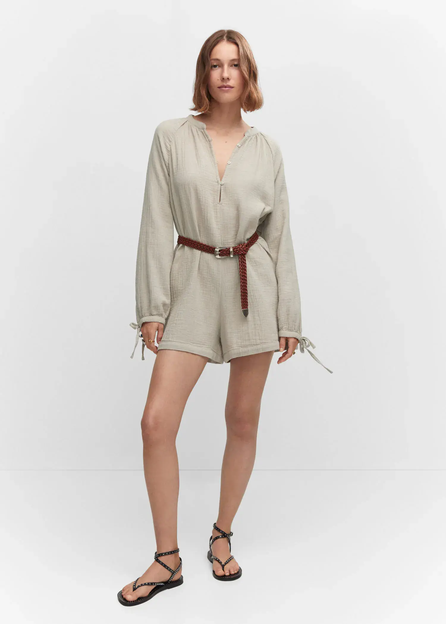 Mango Short jumpsuit with buttons. a woman in a beige outfit is posing. 