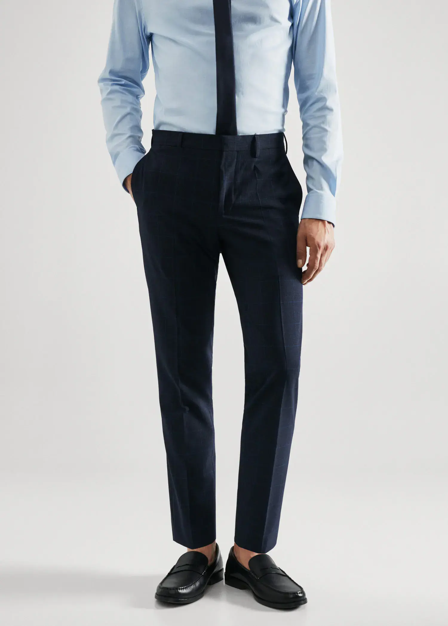 Mango Super slim-fit Tailored check trousers. a man wearing a suit and tie standing in front of a white wall. 