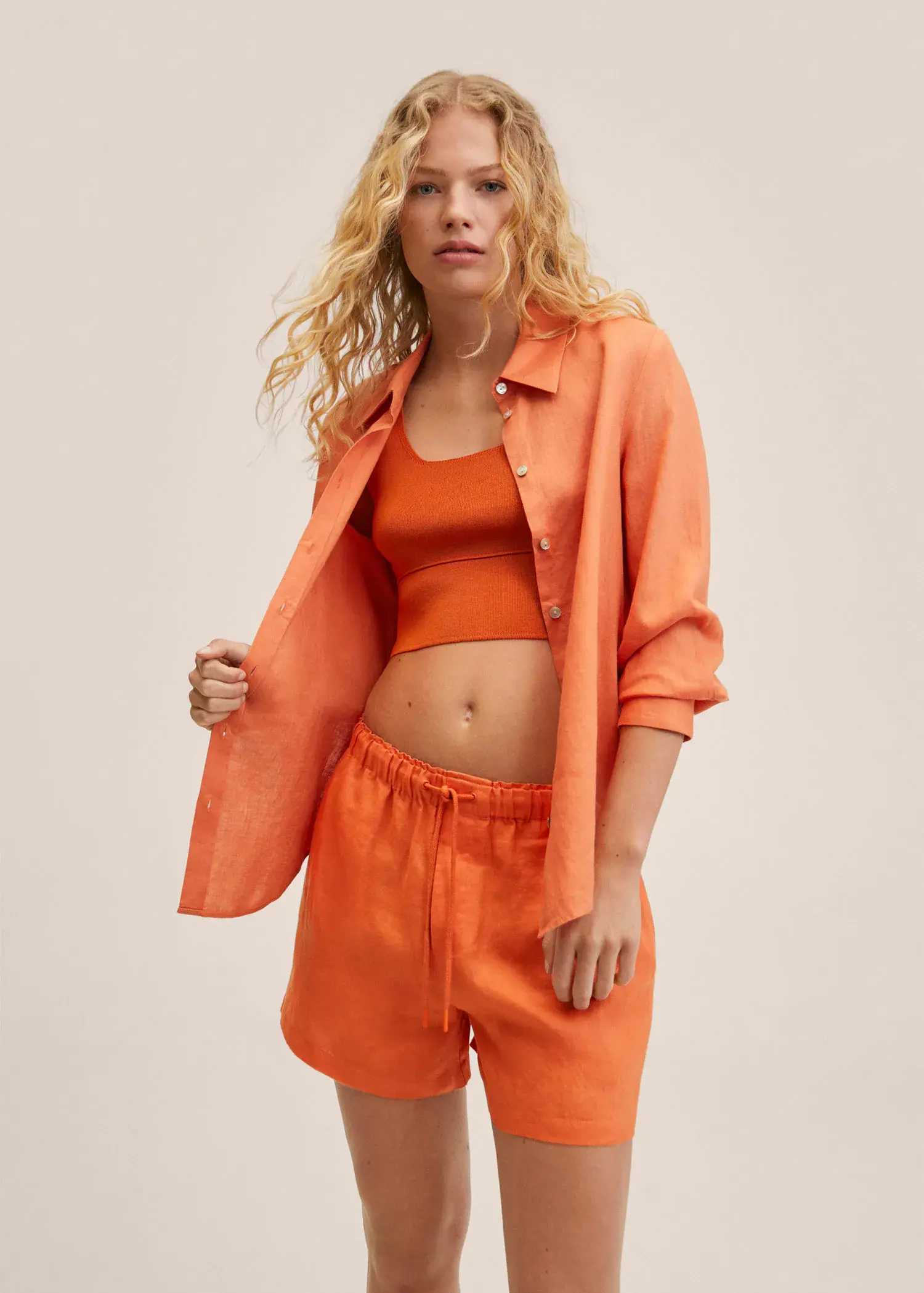 Mango 100% linen shorts. a woman in orange shorts and a orange shirt. 