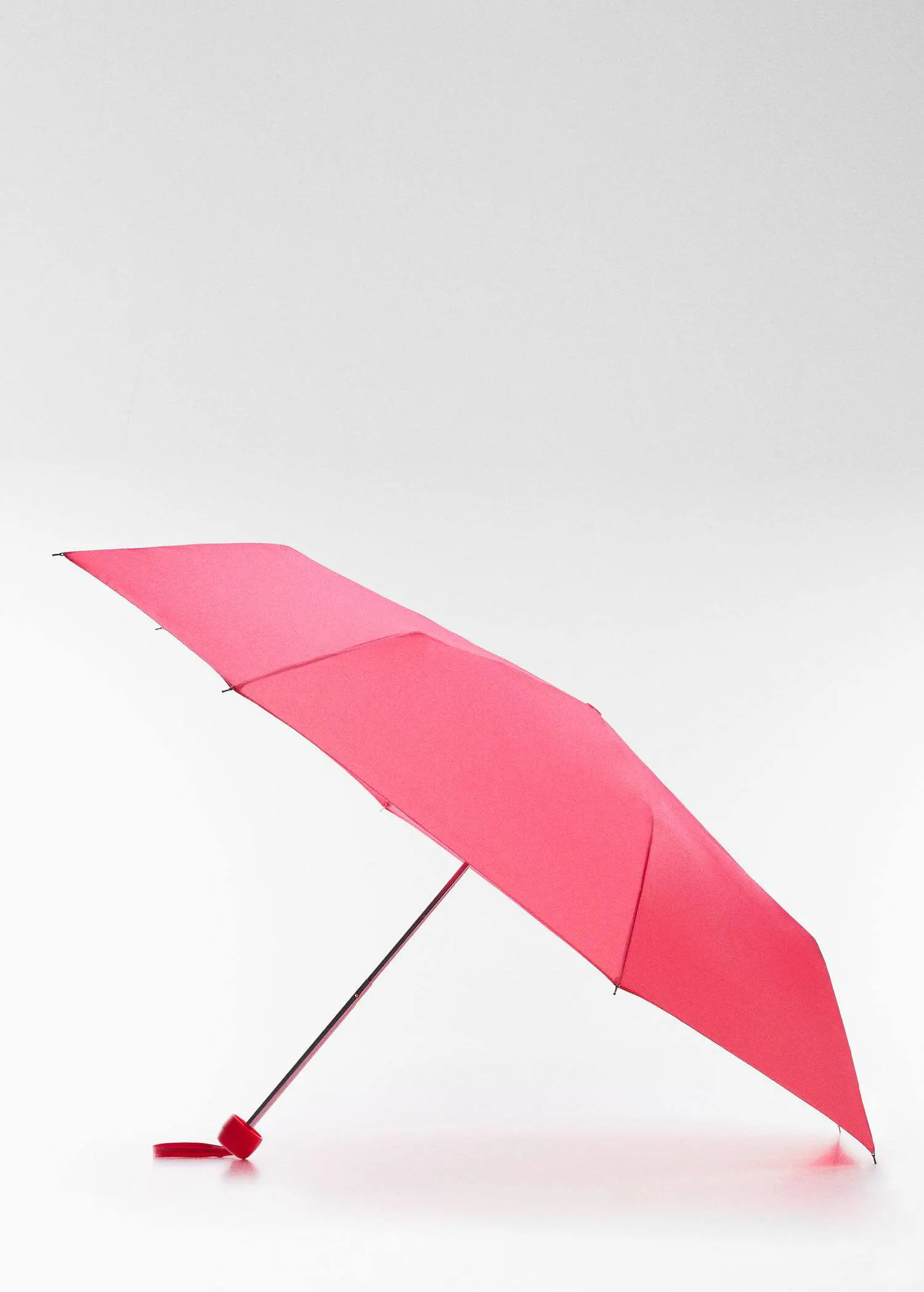 Mango Plain folding umbrella. an open pink umbrella on top of a white surface. 