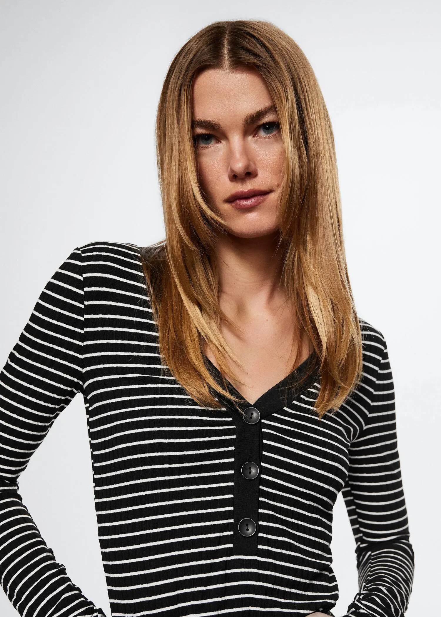 Mango Buttoned ribbed t-shirt. a beautiful woman with long blonde hair wearing a black and white shirt. 