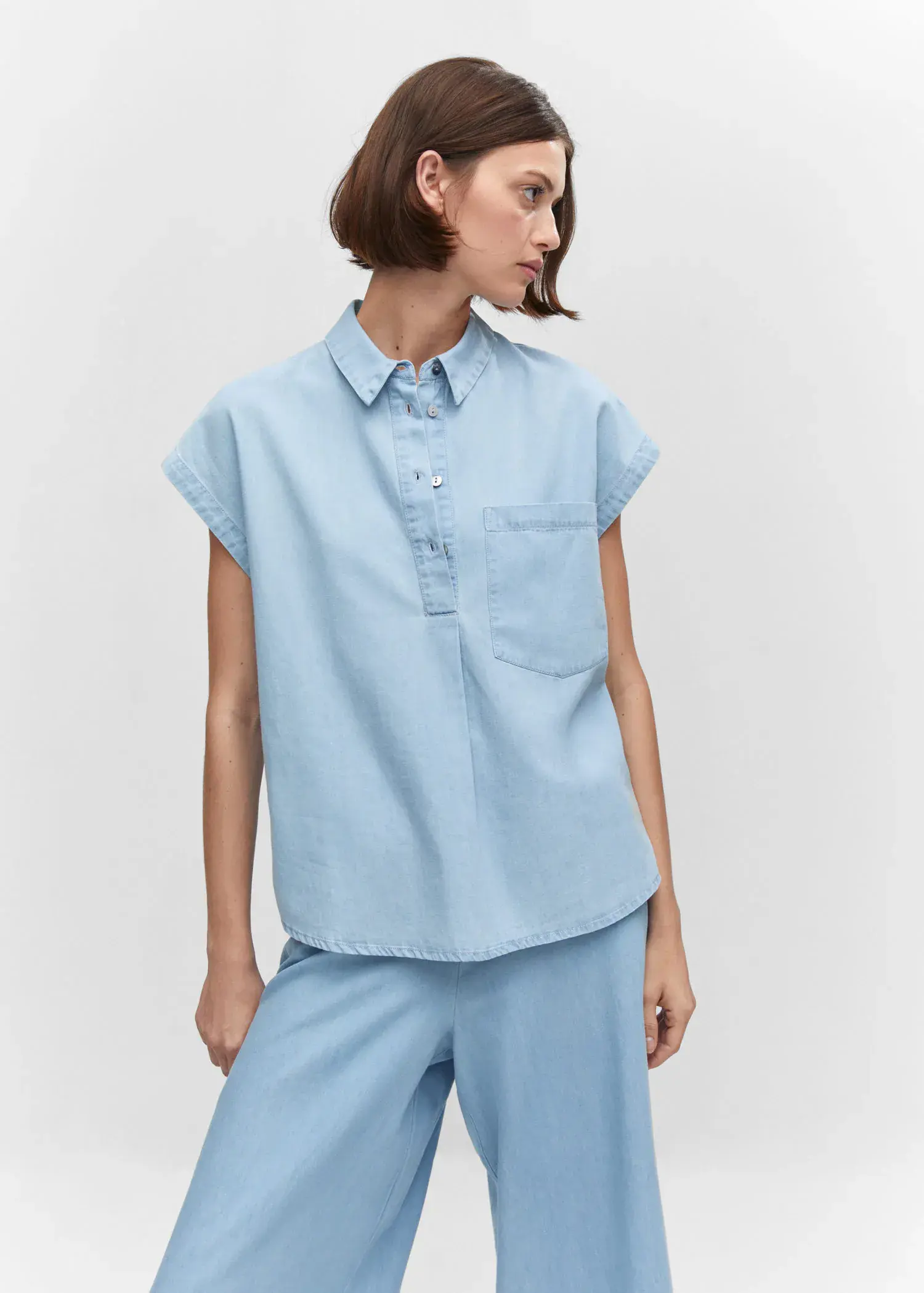 Mango Chest-pocket cotton shirt. a woman wearing a light blue shirt and shorts. 