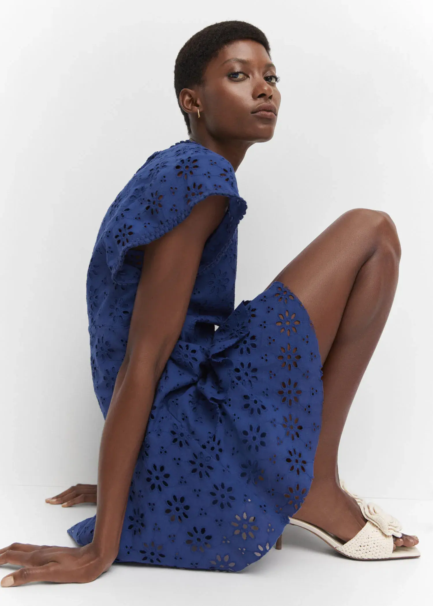 Mango Embroidered openwork dress. a woman sitting on the ground wearing a blue dress. 