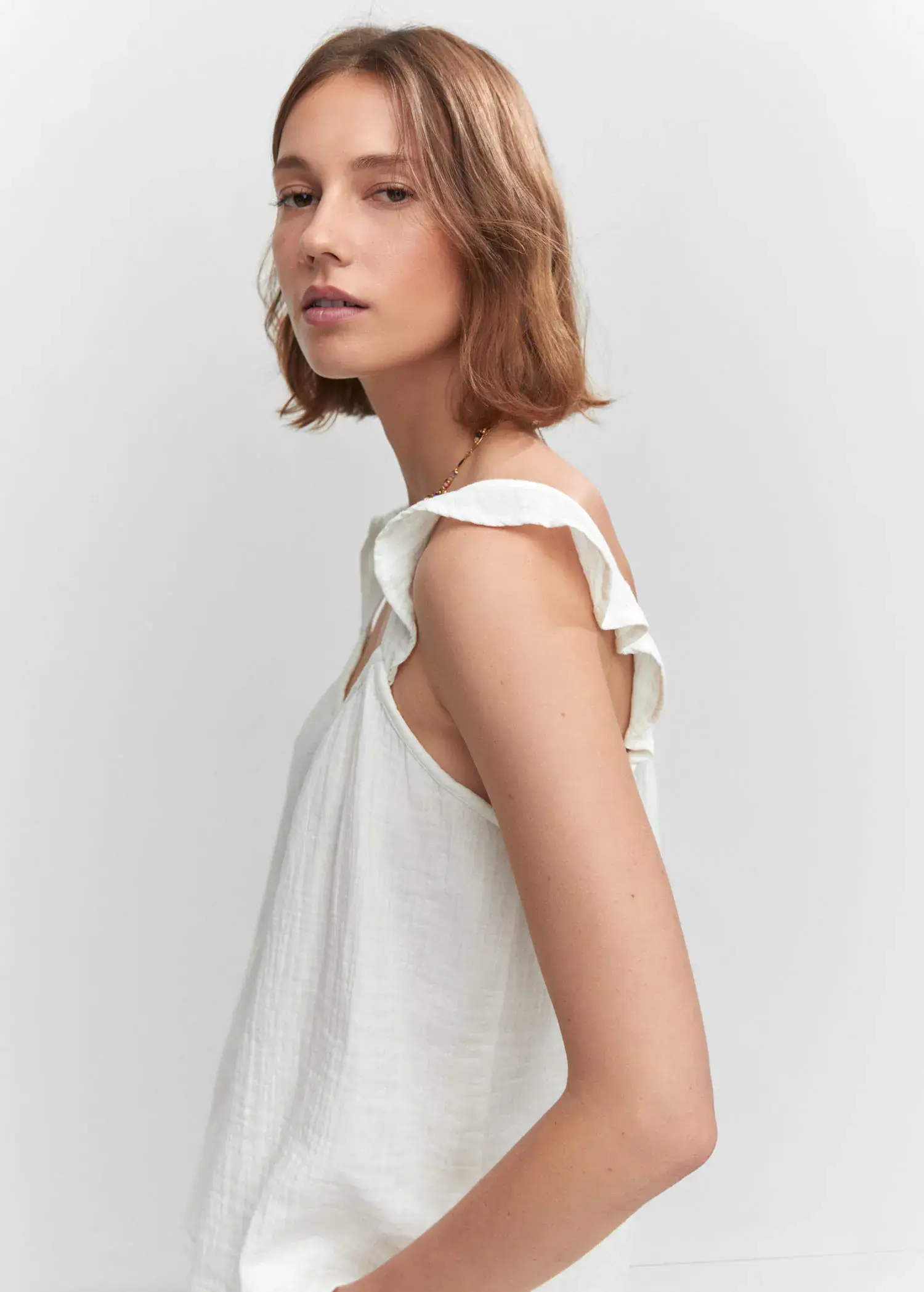 Mango Ruffled strap top. a woman wearing a white top and a necklace. 