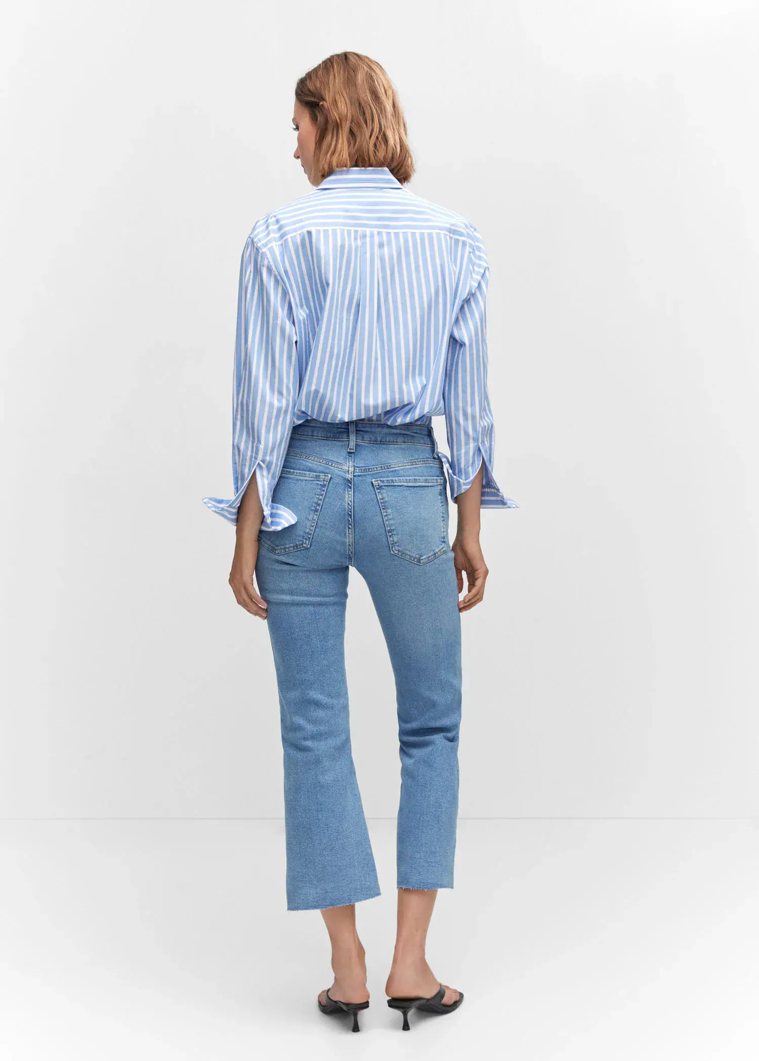 Mango Crop flared jeans. a woman wearing a blue and white striped shirt and jeans. 