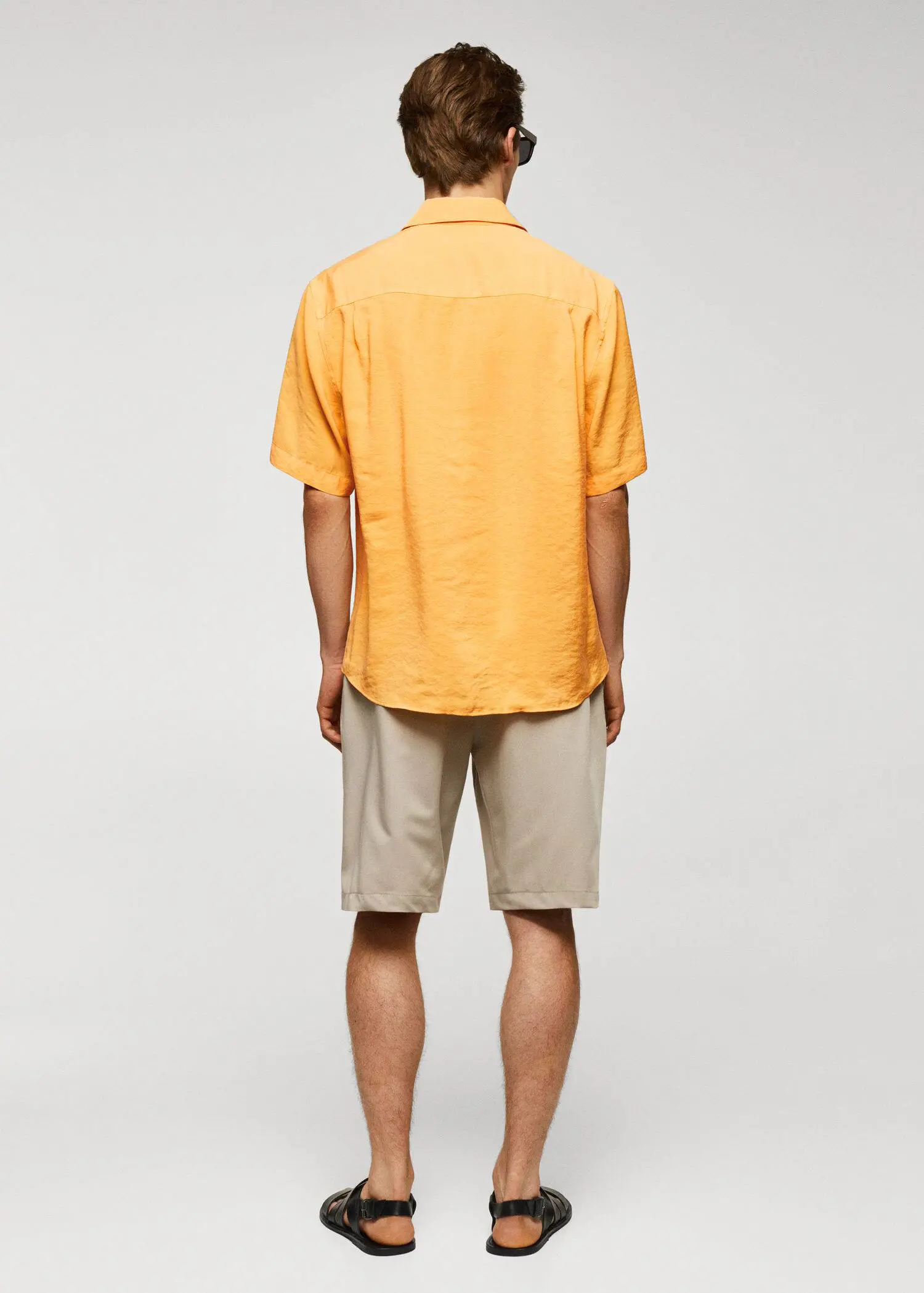 Mango Regular-fit short-sleeved shirt. a man in a yellow shirt and tan shorts. 