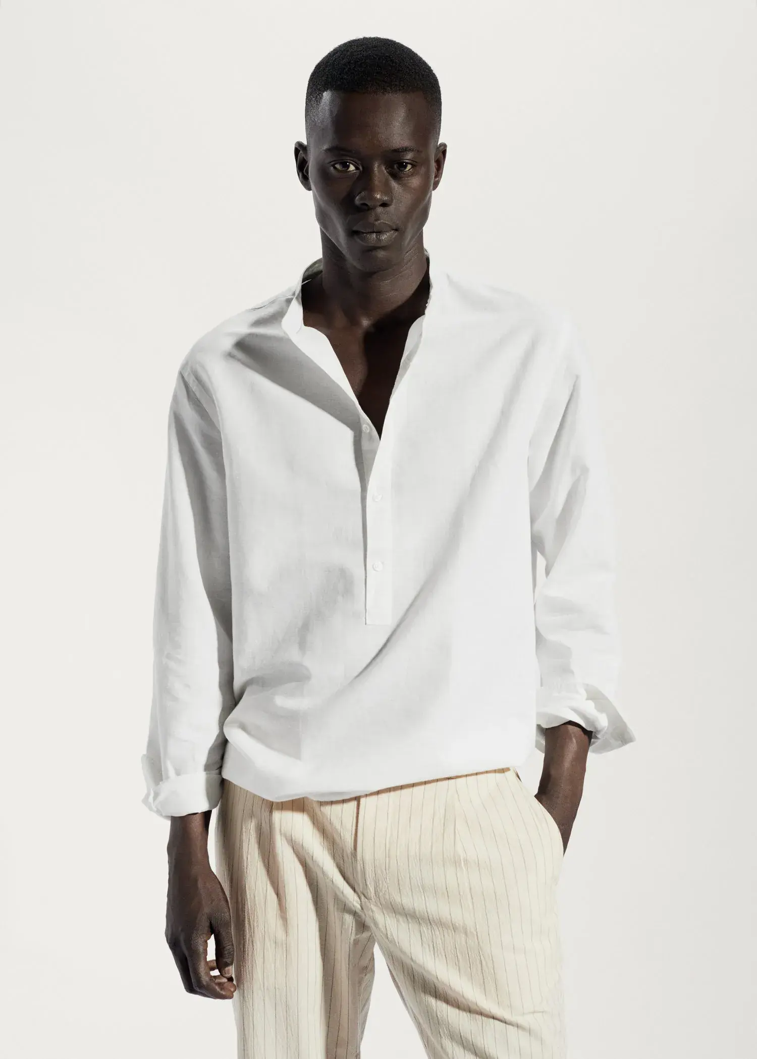 Mango Regular-fit linen shirt with mao collar. a man wearing a white shirt and white pants. 