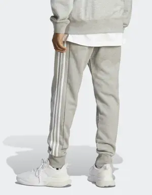 Adidas Essentials French Terry Tapered Cuff 3-Stripes Joggers. 2 Adidas Essentials French Terry Tapered Cuff 3-Stripes Joggers. 2