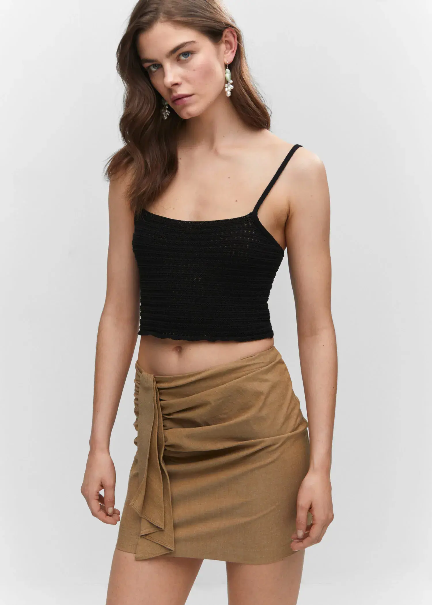 Mango Ruched details skirt. a woman wearing a black top and a brown skirt. 
