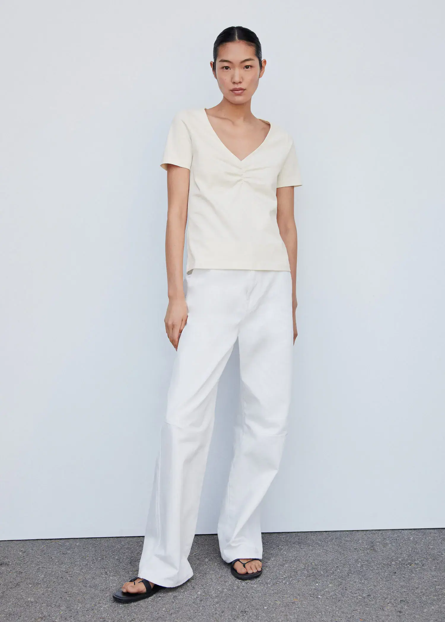 Mango Cotton t-shirt with pucker detail. a woman wearing white pants and a white top. 