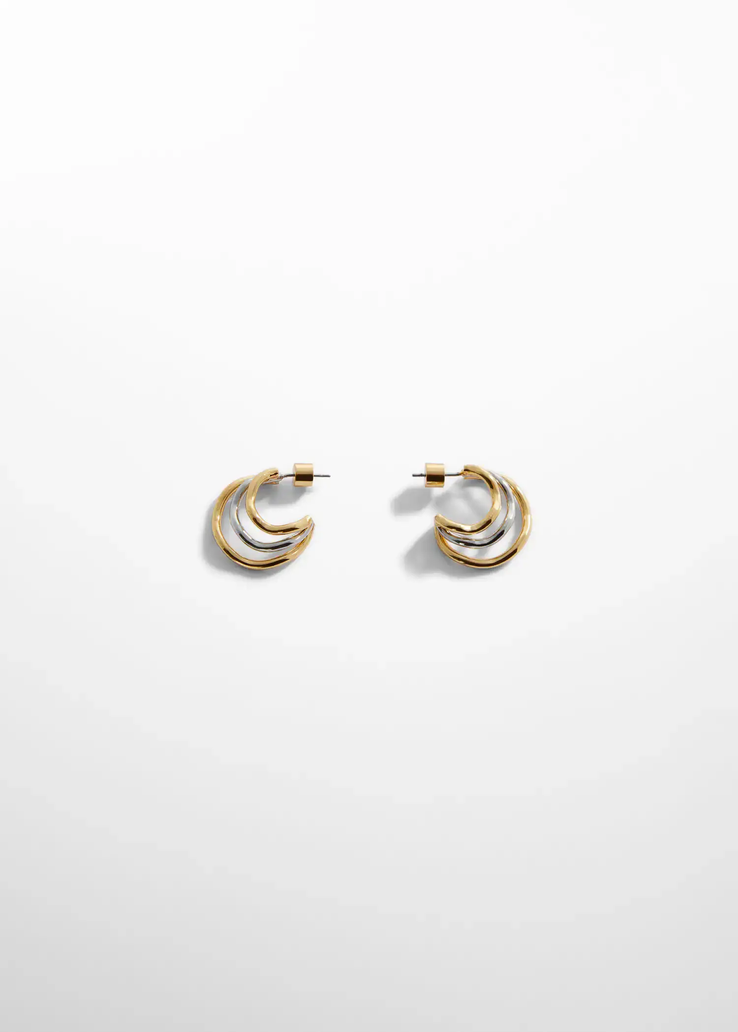 Mango Two-tone hoop earrings. a pair of gold and silver earrings sitting on top of a table. 