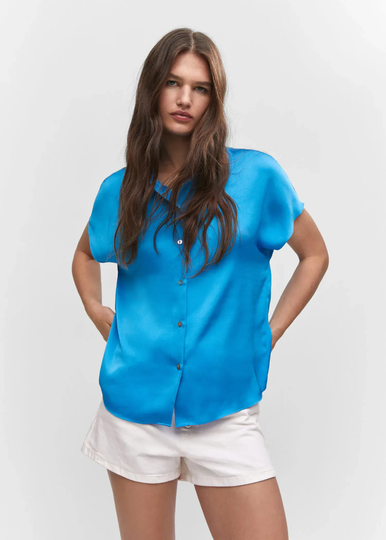 Mango Short-sleeve button-down shirt. a woman wearing a blue shirt and white pants. 