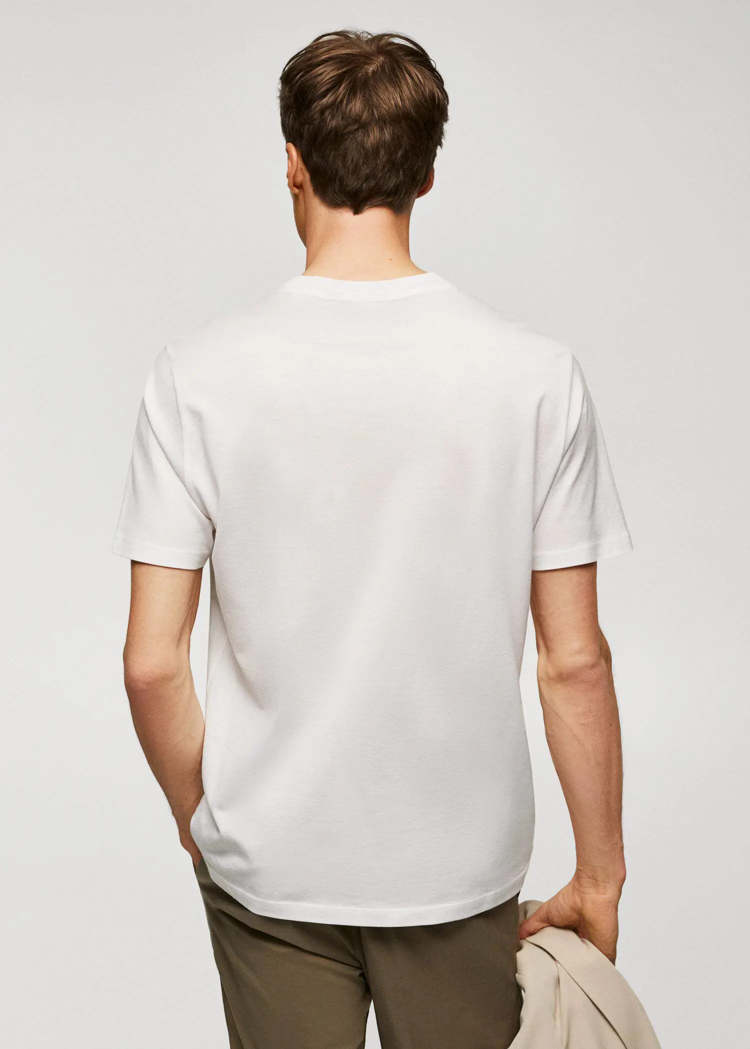 Mango Mercerised regular-fit t-shirt. a man in a white shirt is standing with his hands in his pockets. 