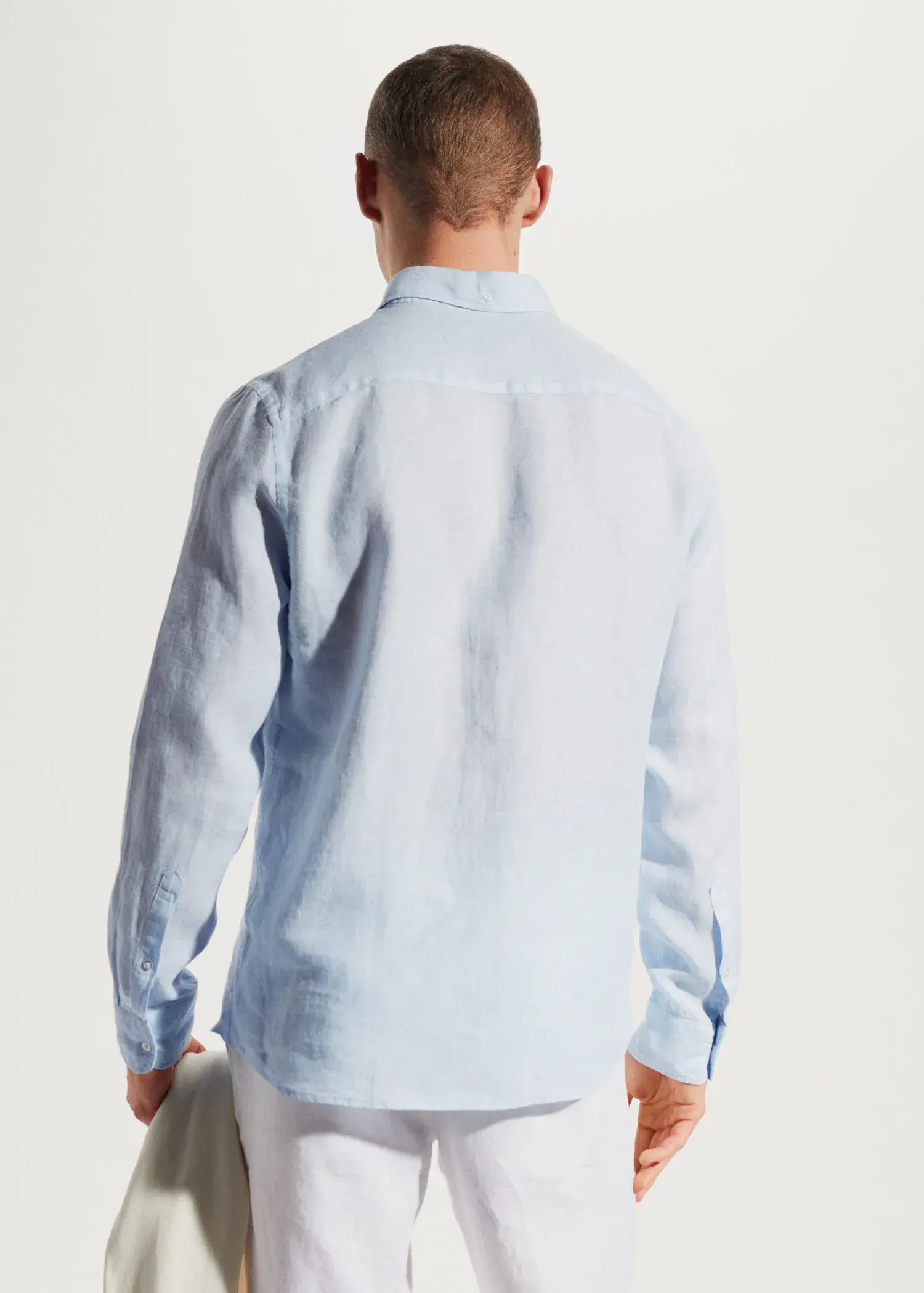 Mango 100% linen slim-fit shirt. a man wearing a light blue shirt and white pants. 