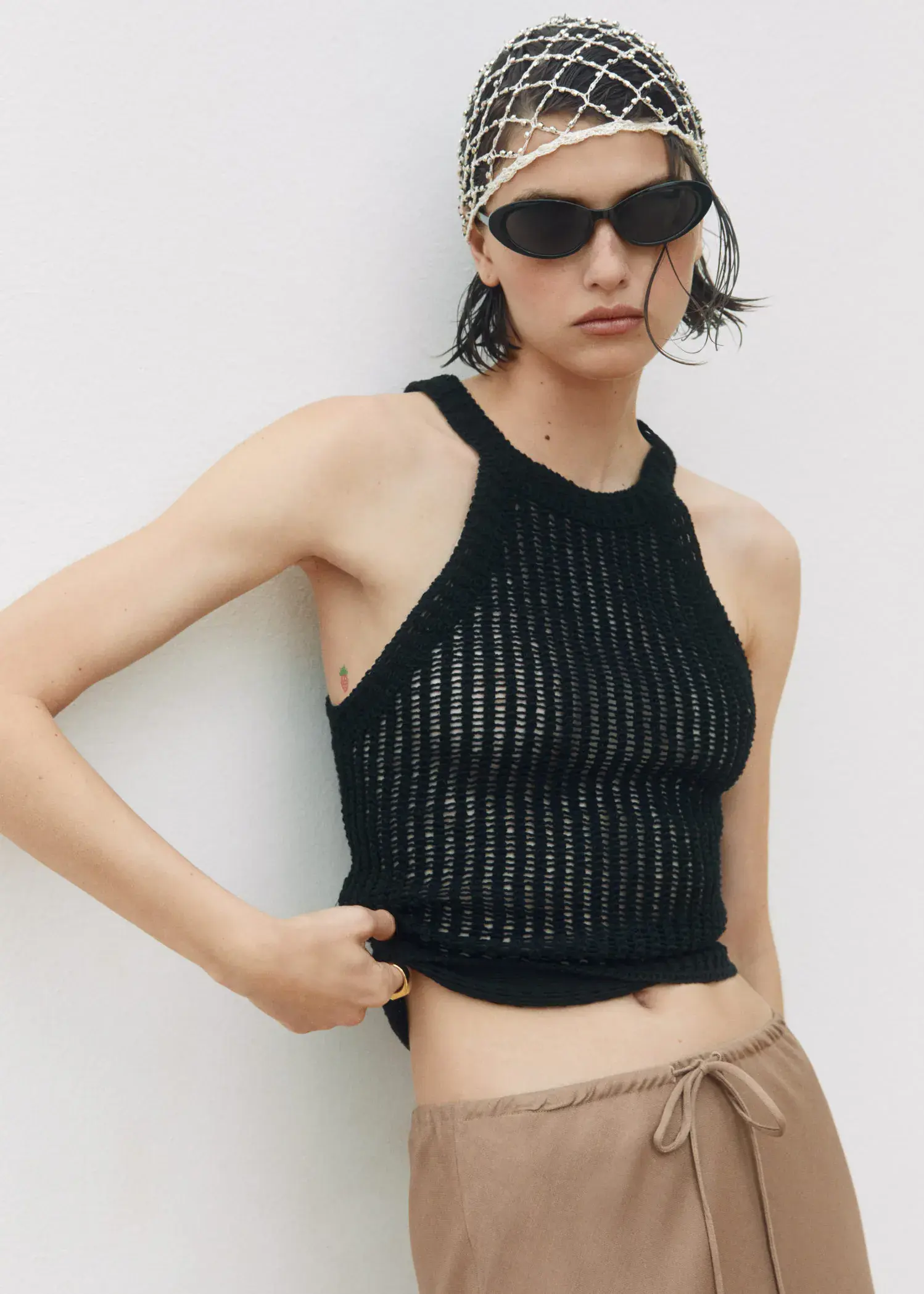 Mango Halter-neck knitted top. a woman wearing sunglasses and a black tank top. 