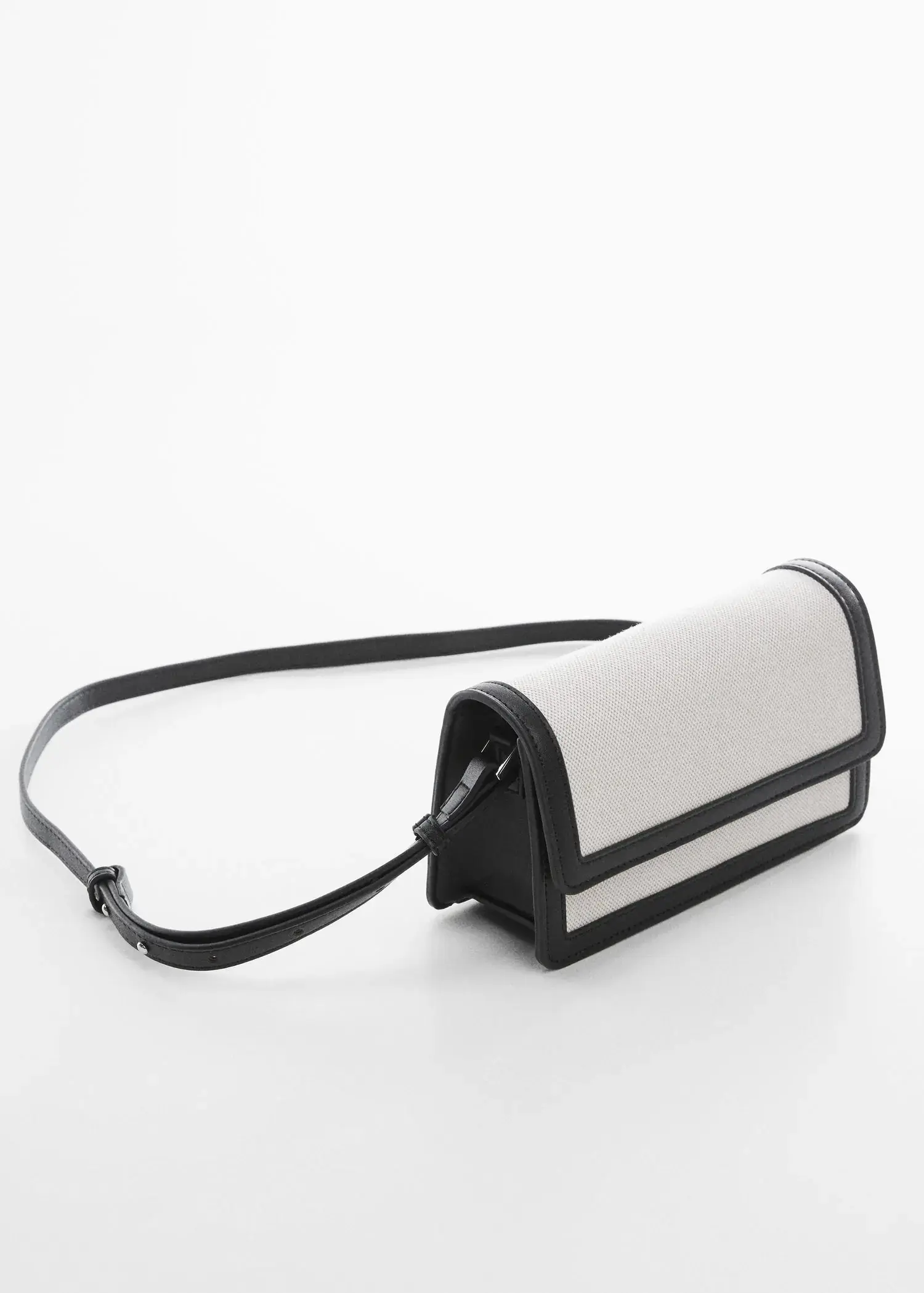 Mango Textured bag with flap. a black and white purse sitting on top of a table. 