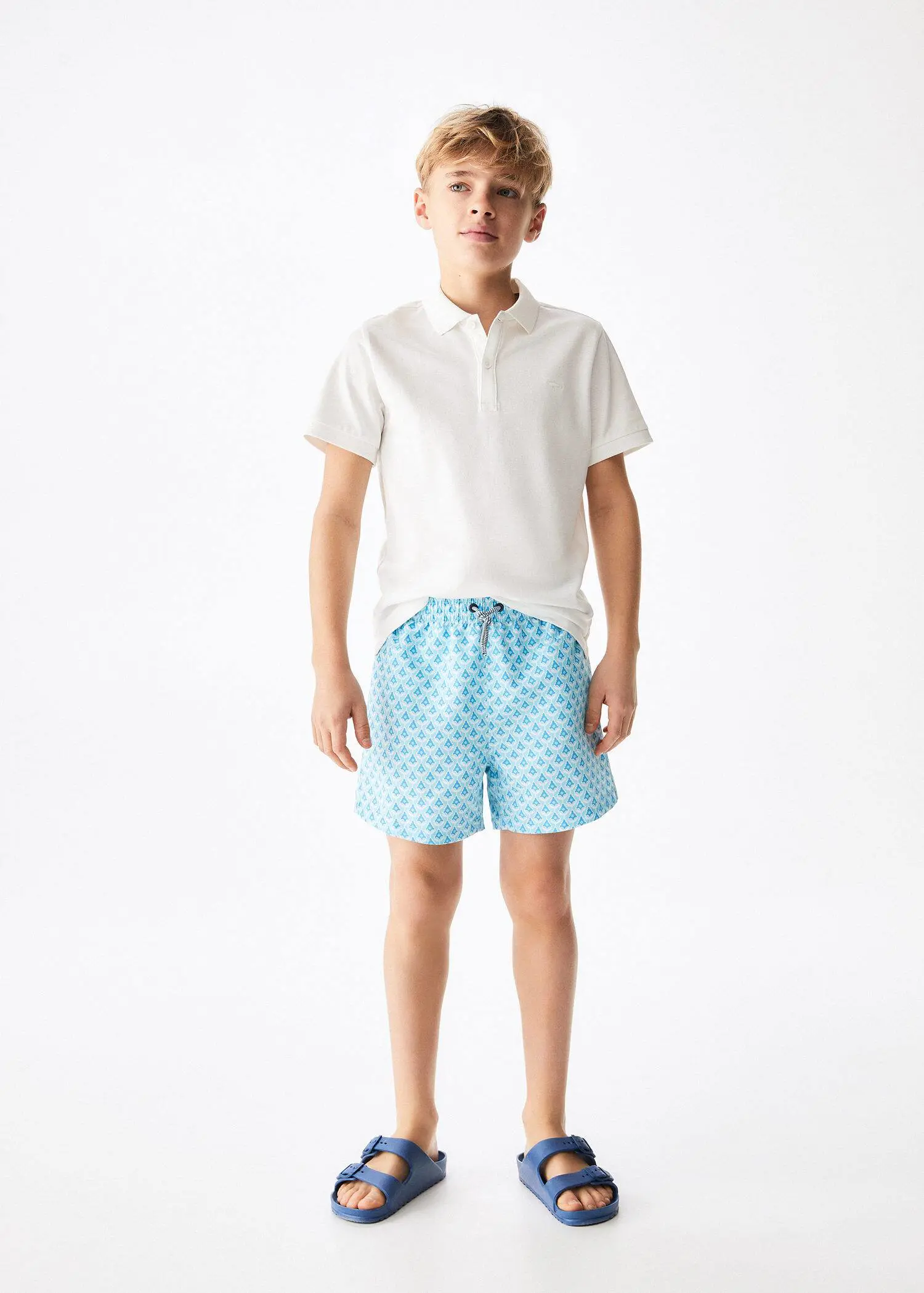 Mango KIDS/ Printed swimsuit. a young man wearing a pair of blue shorts. 