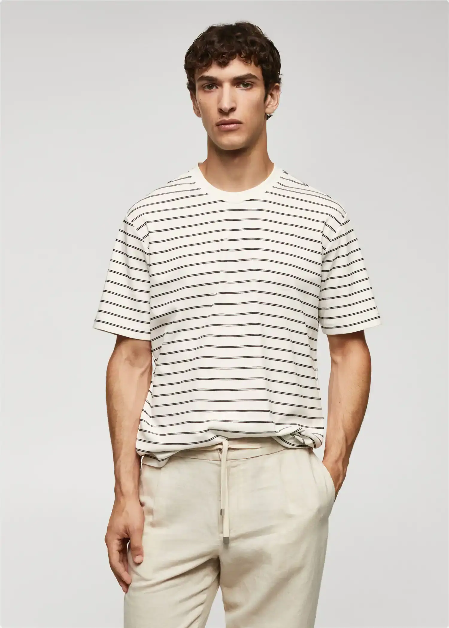 Mango Striped 100% cotton t-shirt. a man wearing a striped shirt and a pair of white pants. 