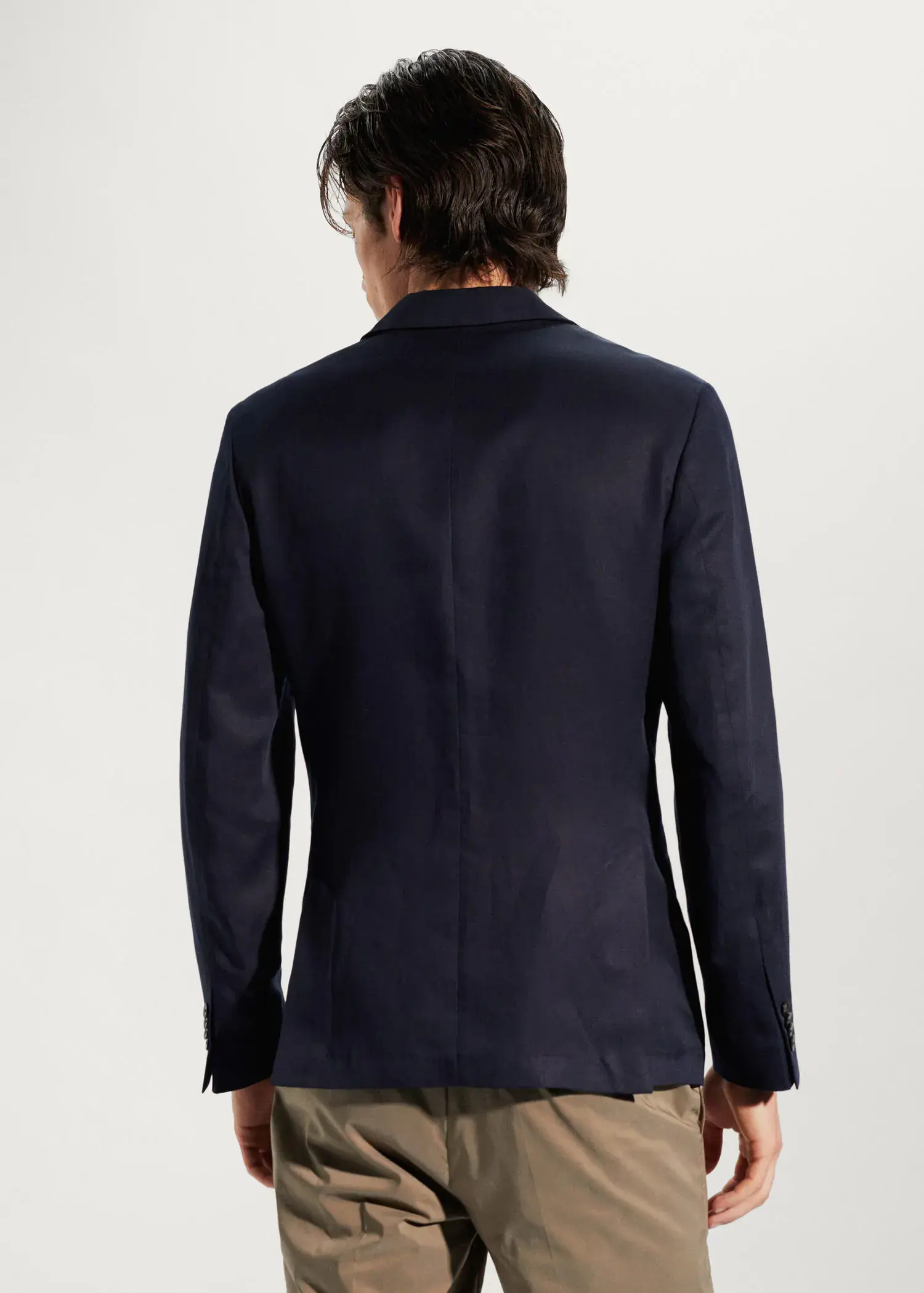 Mango Slim fit linen suit blazer. a man wearing a black jacket standing next to a wall. 