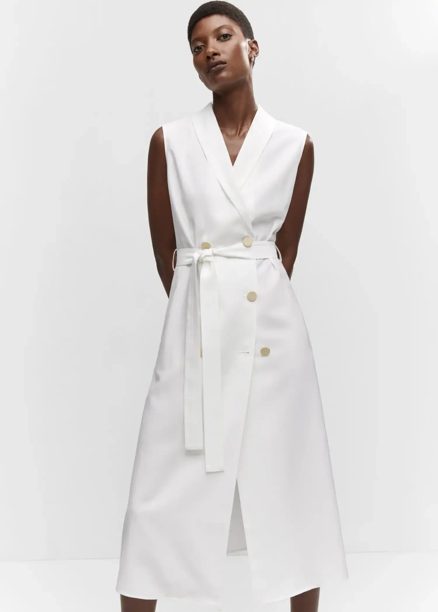 Mango Buttoned wrap dress. a woman wearing a white dress standing in front of a white wall. 