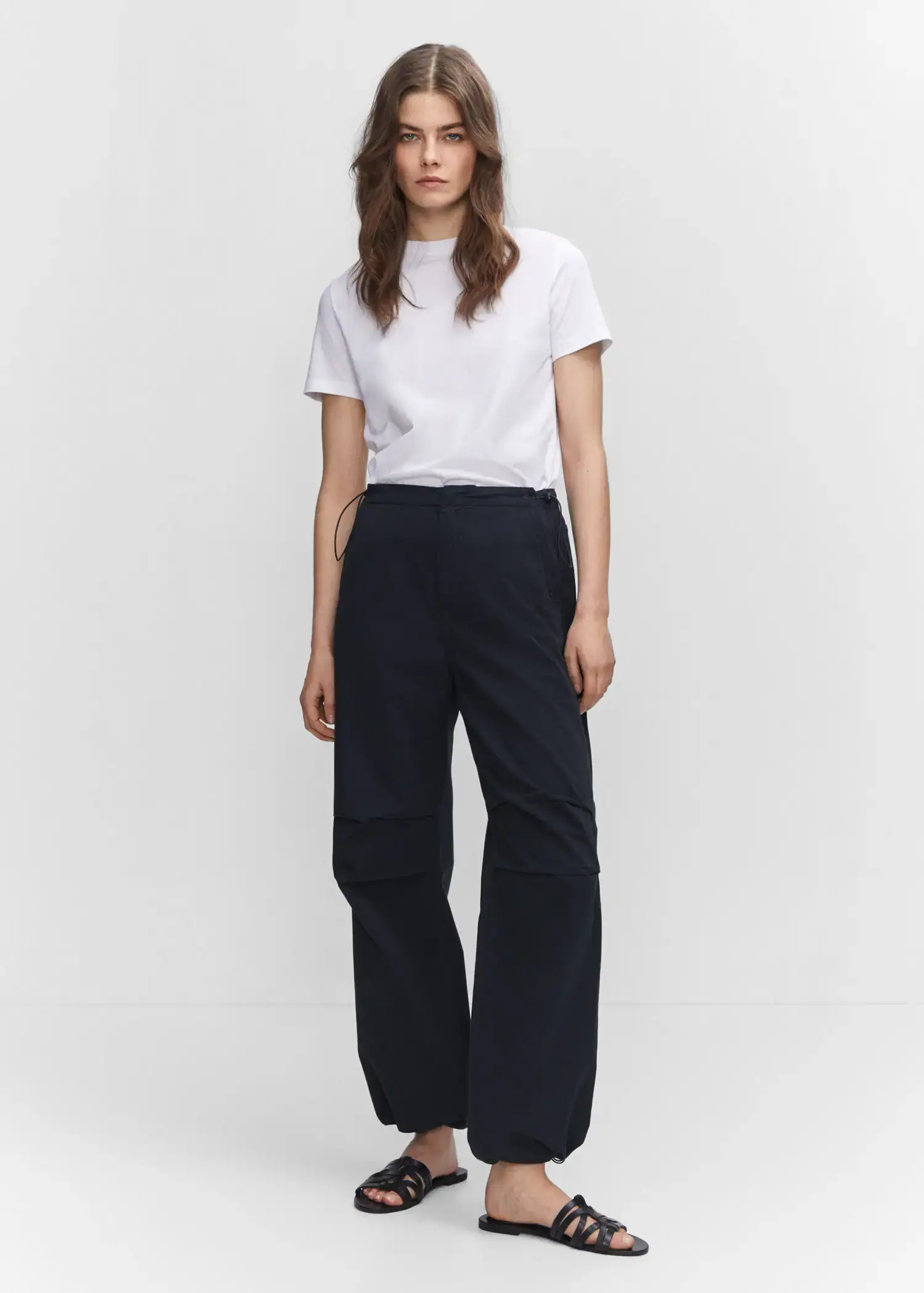 Mango Parachute trousers. a woman standing in front of a white wall. 