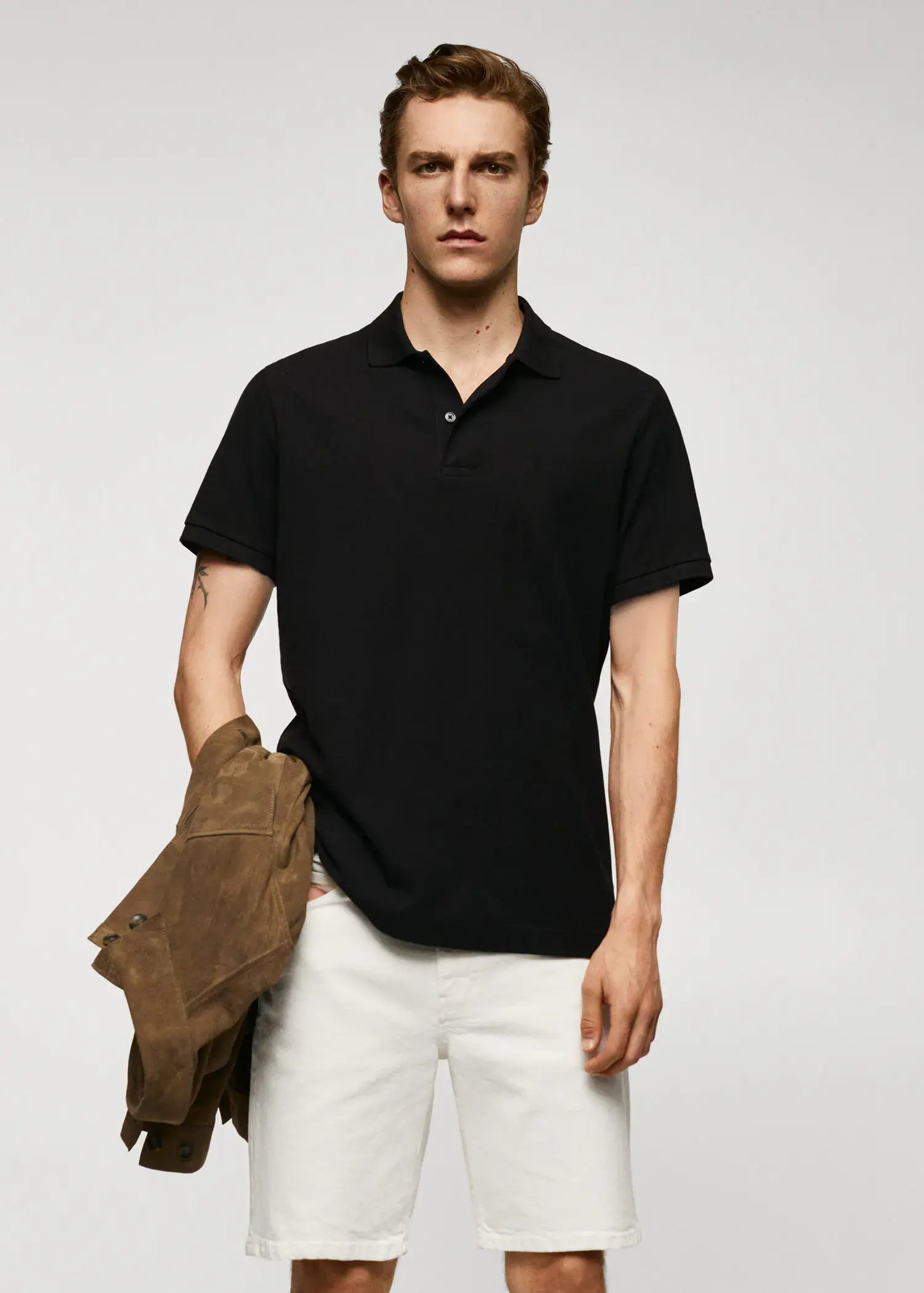 Mango 100% cotton pique polo shirt. a man in a black shirt holding a brown jacket. 