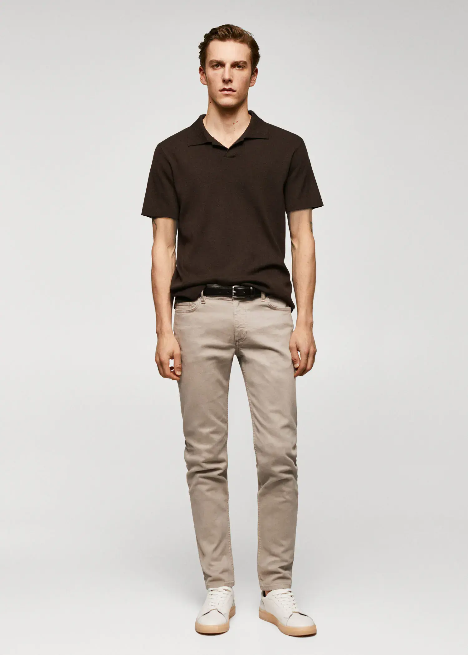 Mango Jan slim-fit jeans. a young man wearing a black shirt and beige pants. 
