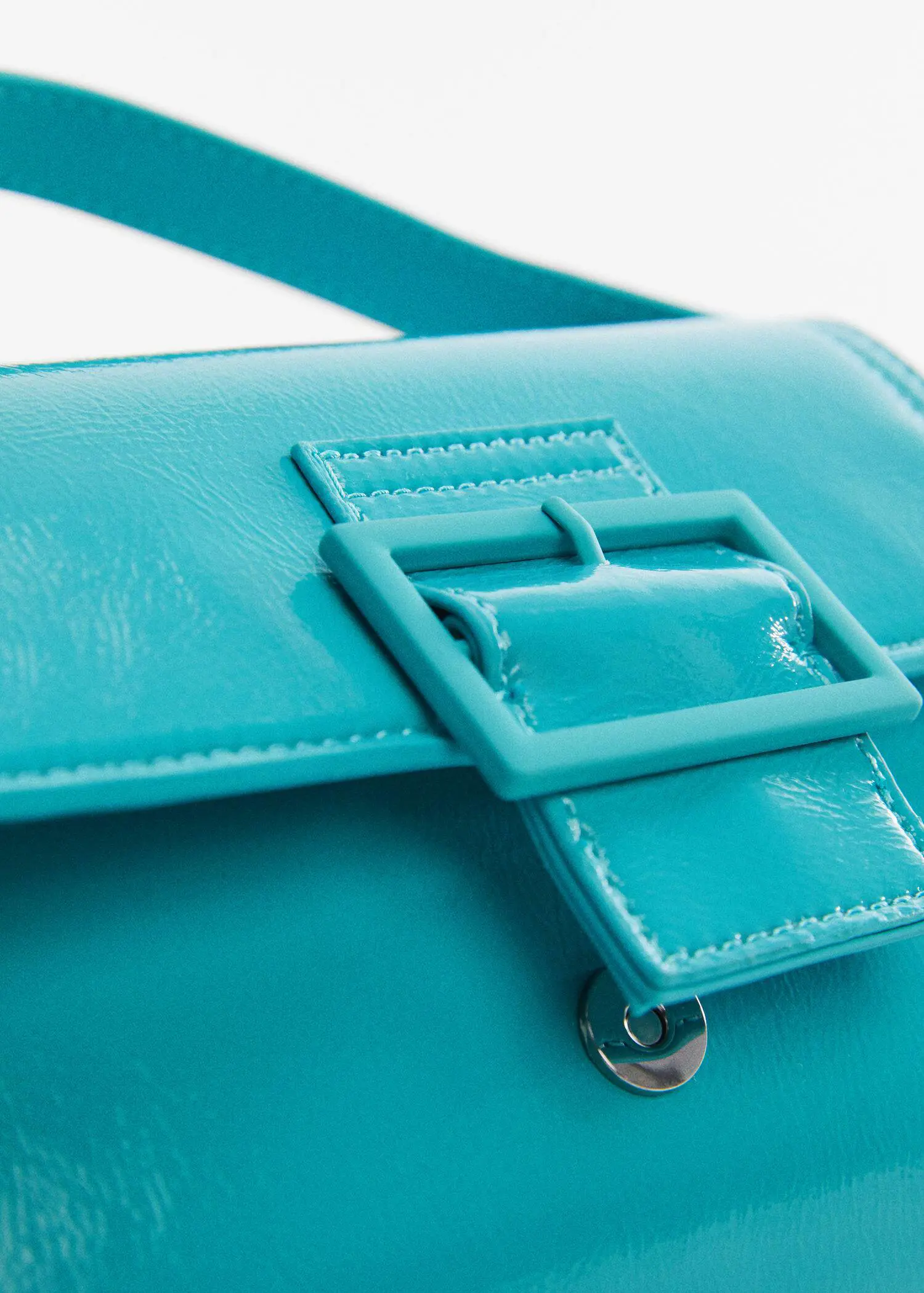 Mango Buckled flap bag. a close-up view of a turquoise purse. 