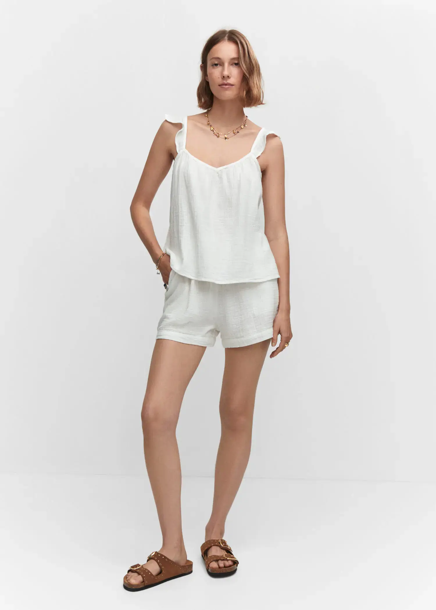 Mango Ruffled strap top. a woman in white shorts and a tank top. 