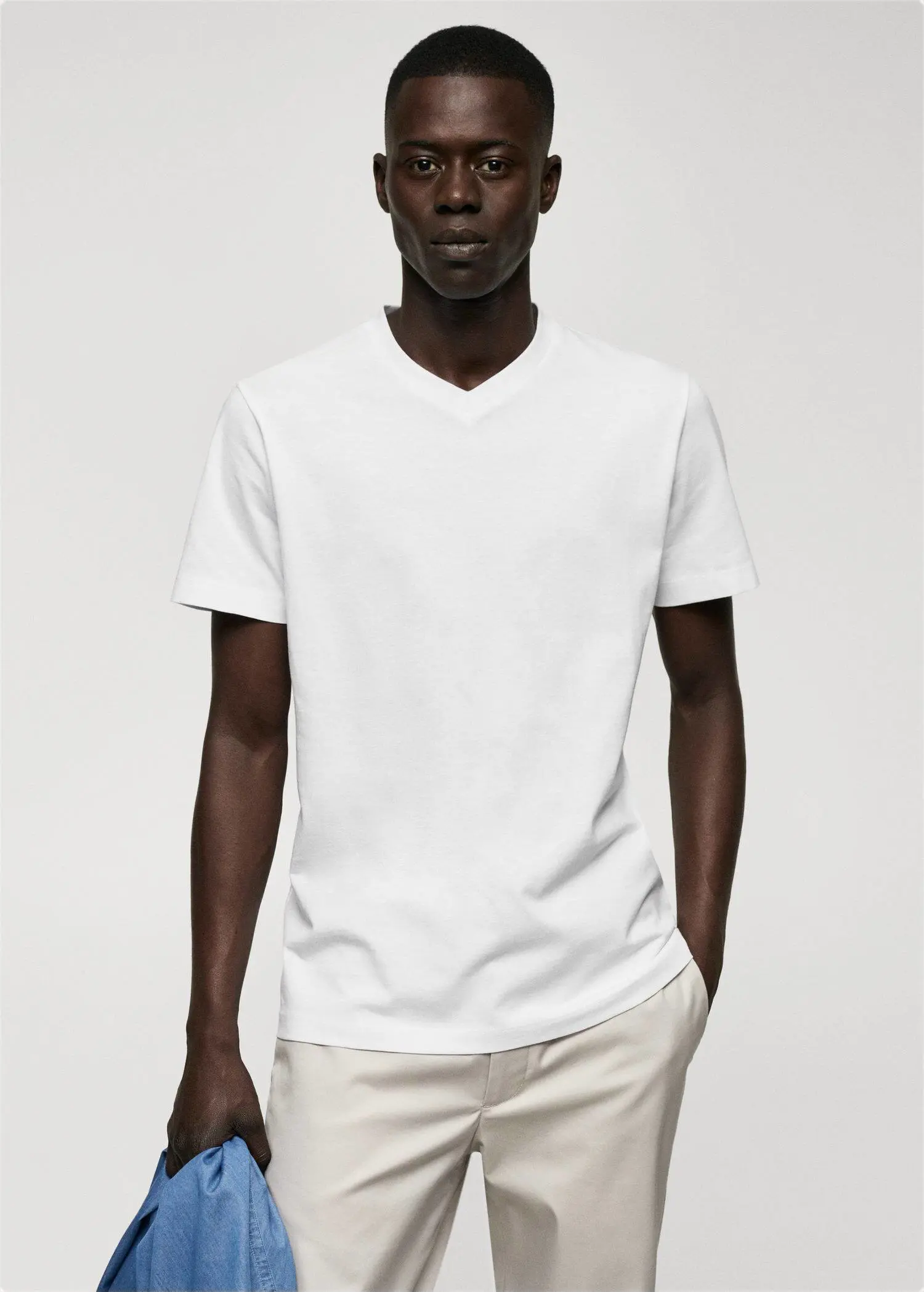 Mango Basic cotton V-neck T-shirt. a man in a white shirt is posing for a picture. 