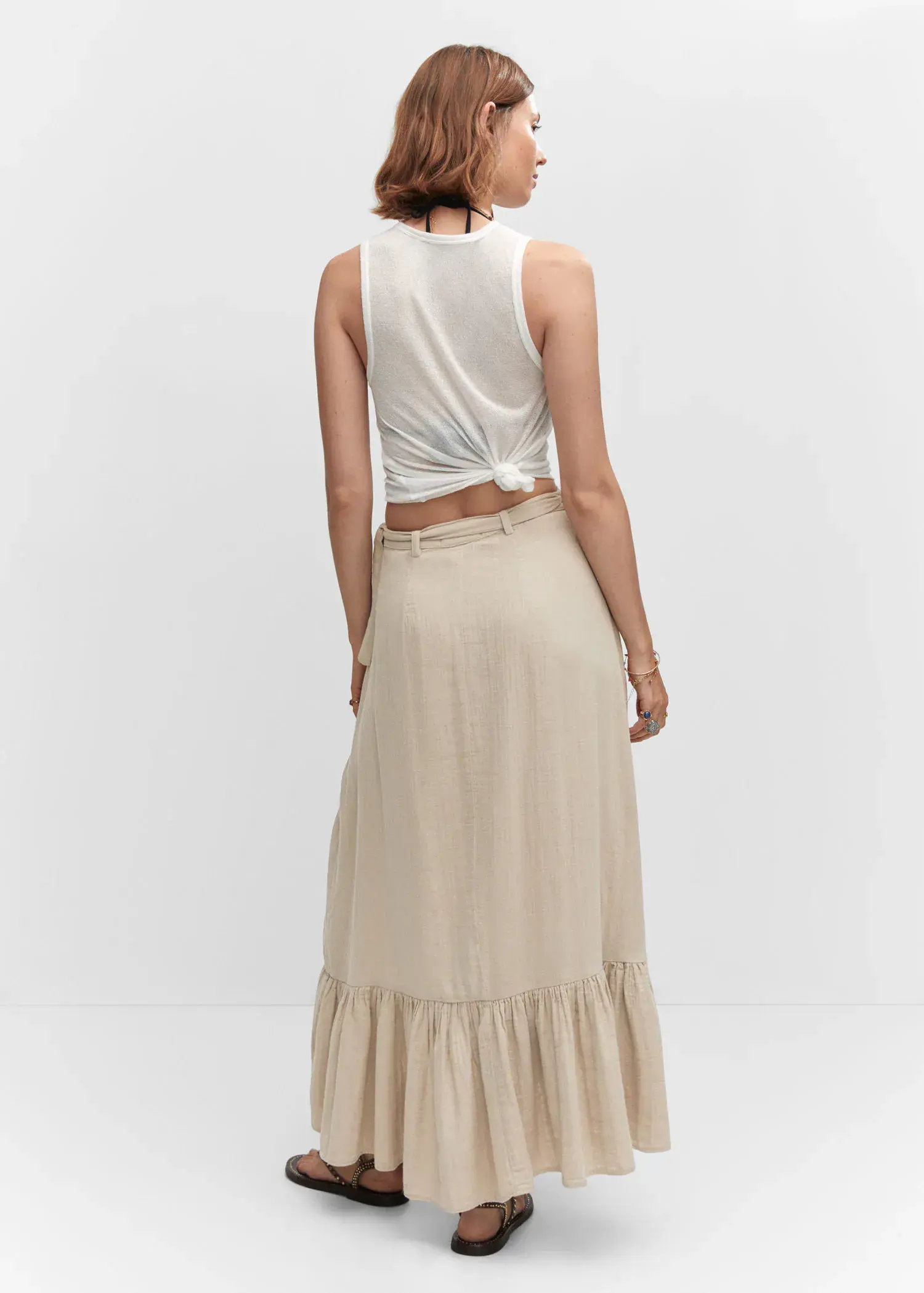Mango Textured criss-cross skirt. a woman wearing a white top and a beige skirt. 