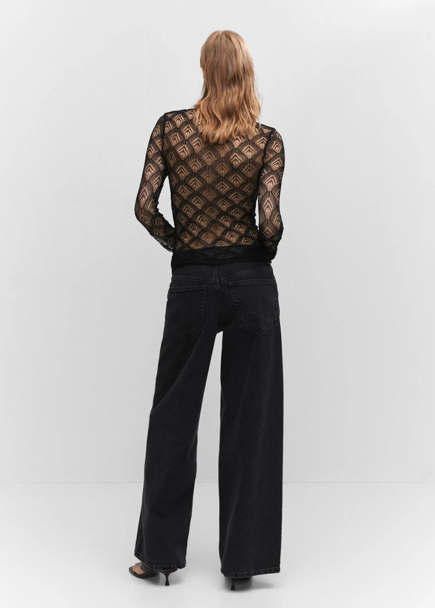 Mango Geometric openwork T-shirt. a woman in a black outfit standing in front of a white wall. 
