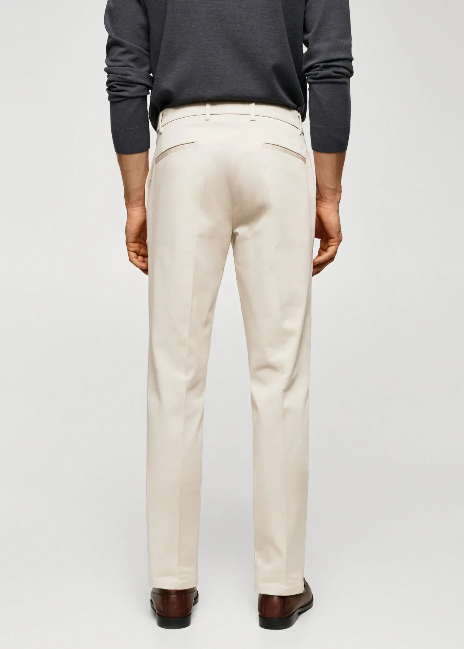Mango Slim fit chino trousers. a man in a black shirt and white pants. 