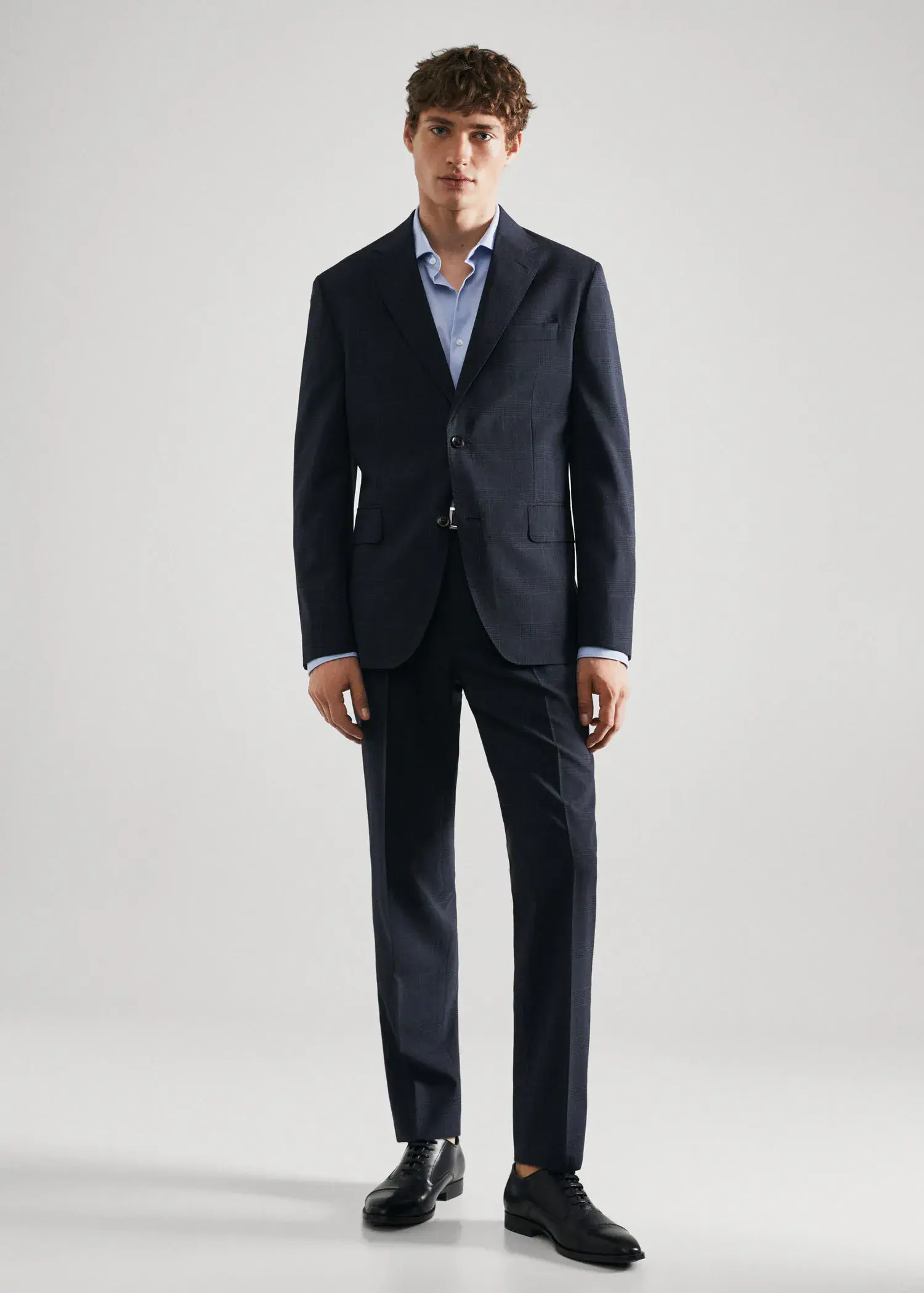 Mango Slim-fit cotton poplin suit shirt. a man in a suit standing in front of a white wall. 