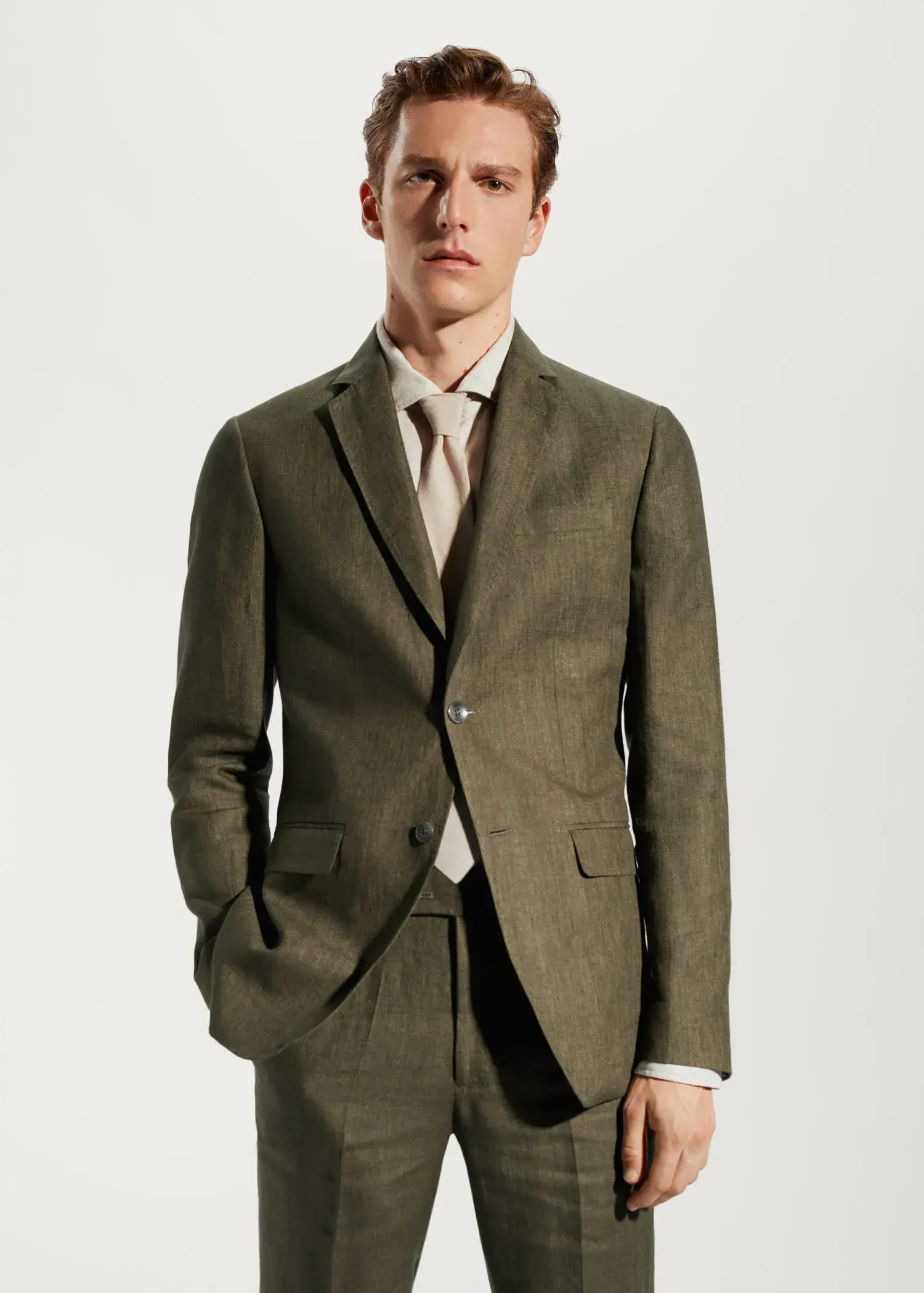 Mango 100% linen suit blazer. a man in a suit and tie standing in front of a wall. 