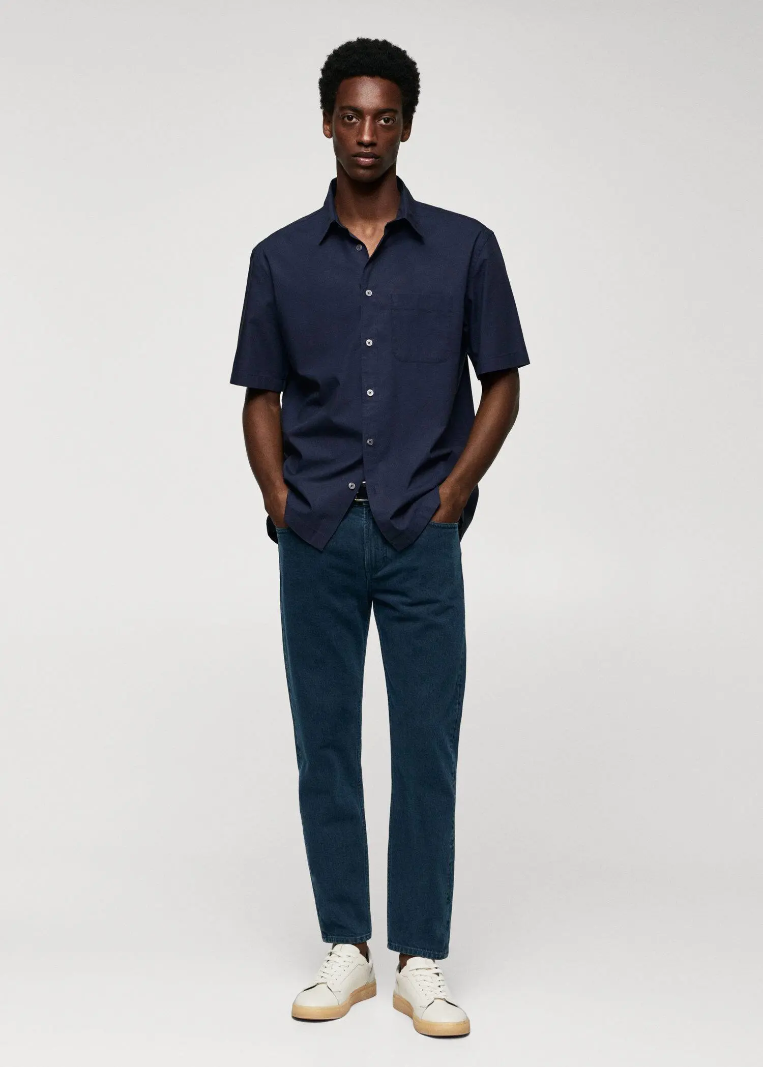 Mango Ben tapered cropped jeans. a man standing in front of a white wall. 