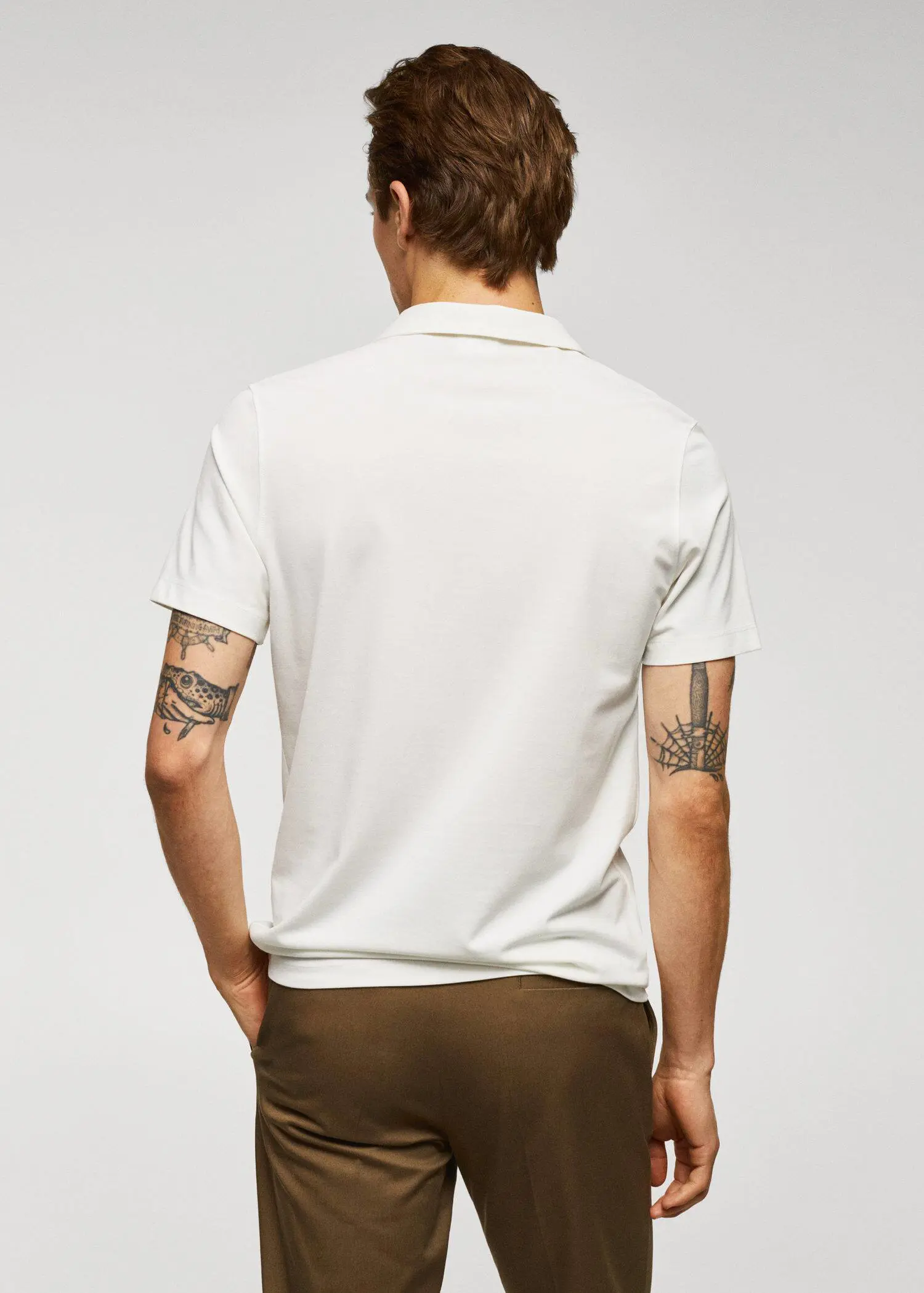 Mango Slim-fit textured cotton polo shirt. a man wearing a white polo shirt and brown shorts. 