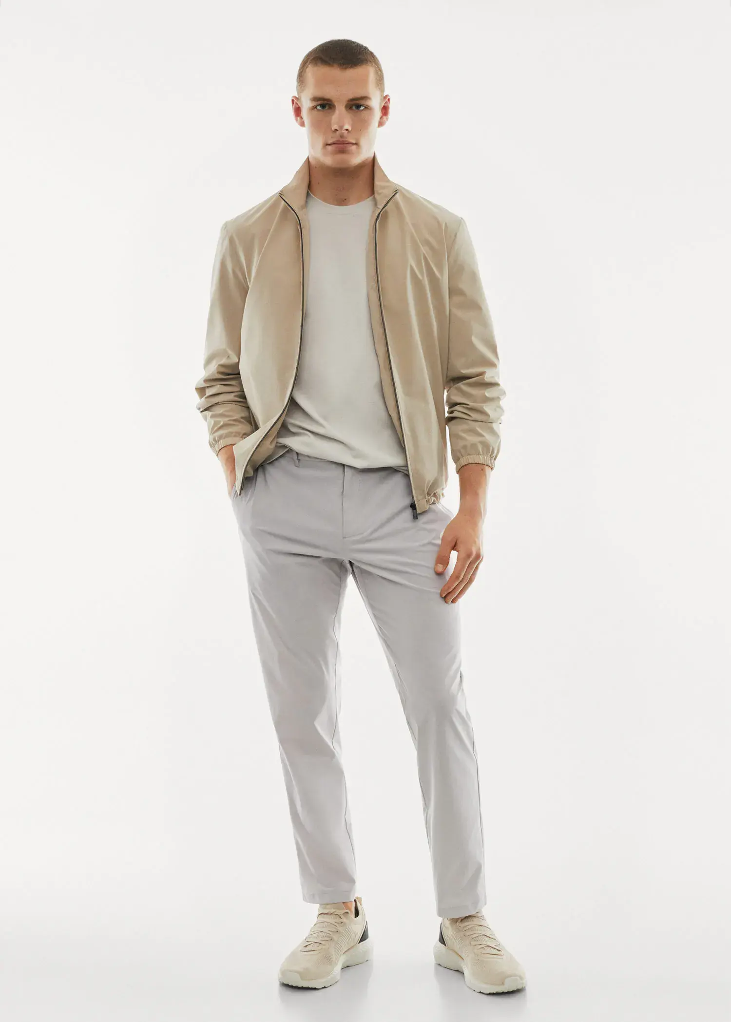 Mango Water-repellent technical trousers. a man in a tan jacket and white shirt. 