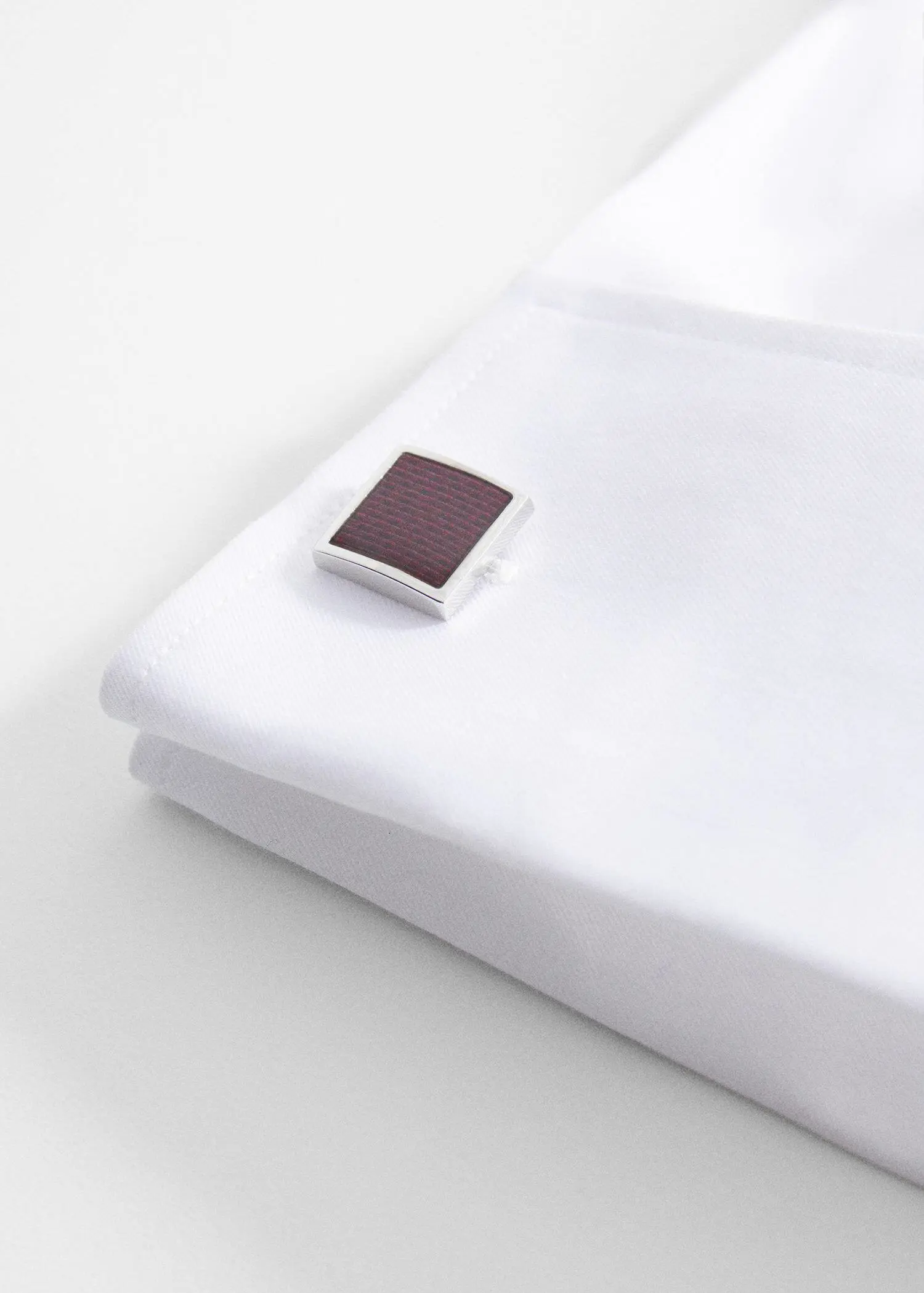 Mango Coloured square cufflinks. a close-up of a white sheet with a brown square on it. 