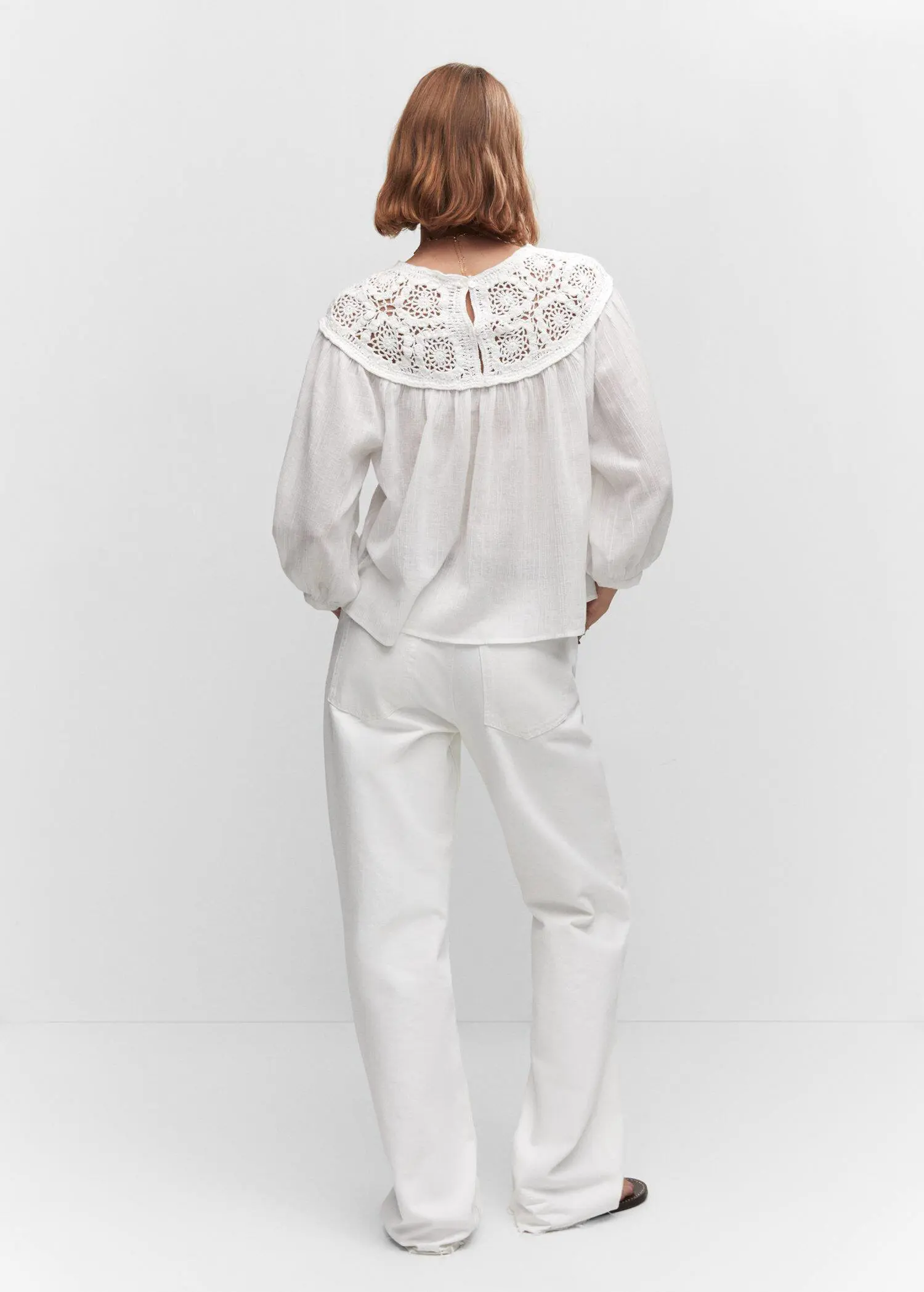 Mango Crochet panel blouse. a person wearing a white outfit standing in front of a wall. 