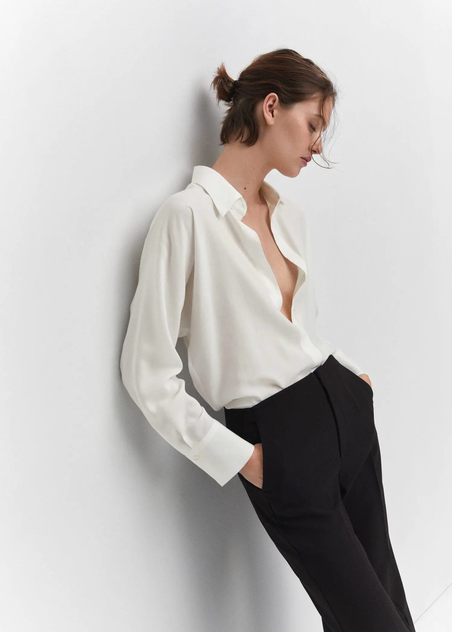 Mango Lyocell fluid shirt. a woman leaning up against a white wall. 
